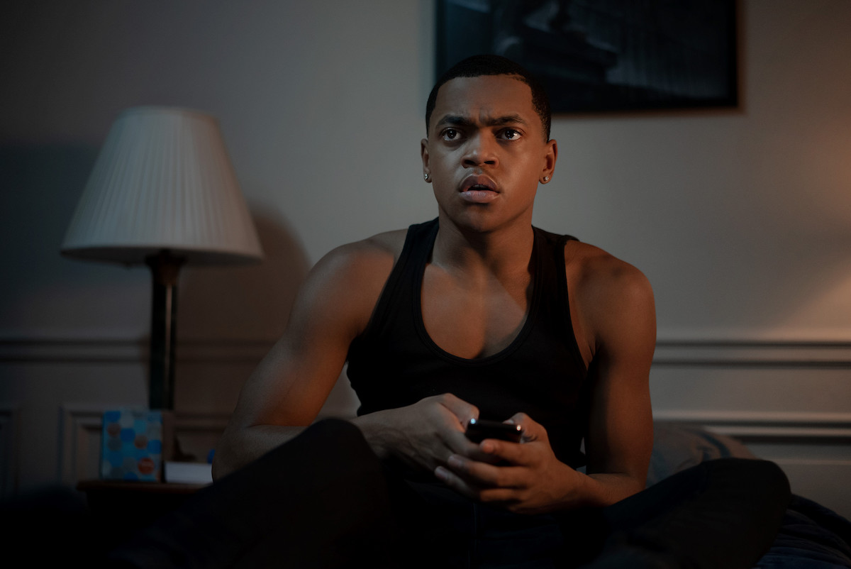 Michael Rainey Jr. as Tariq St. Patrick waring a black tank top and holding a remote in 'Power Book II: Ghost'