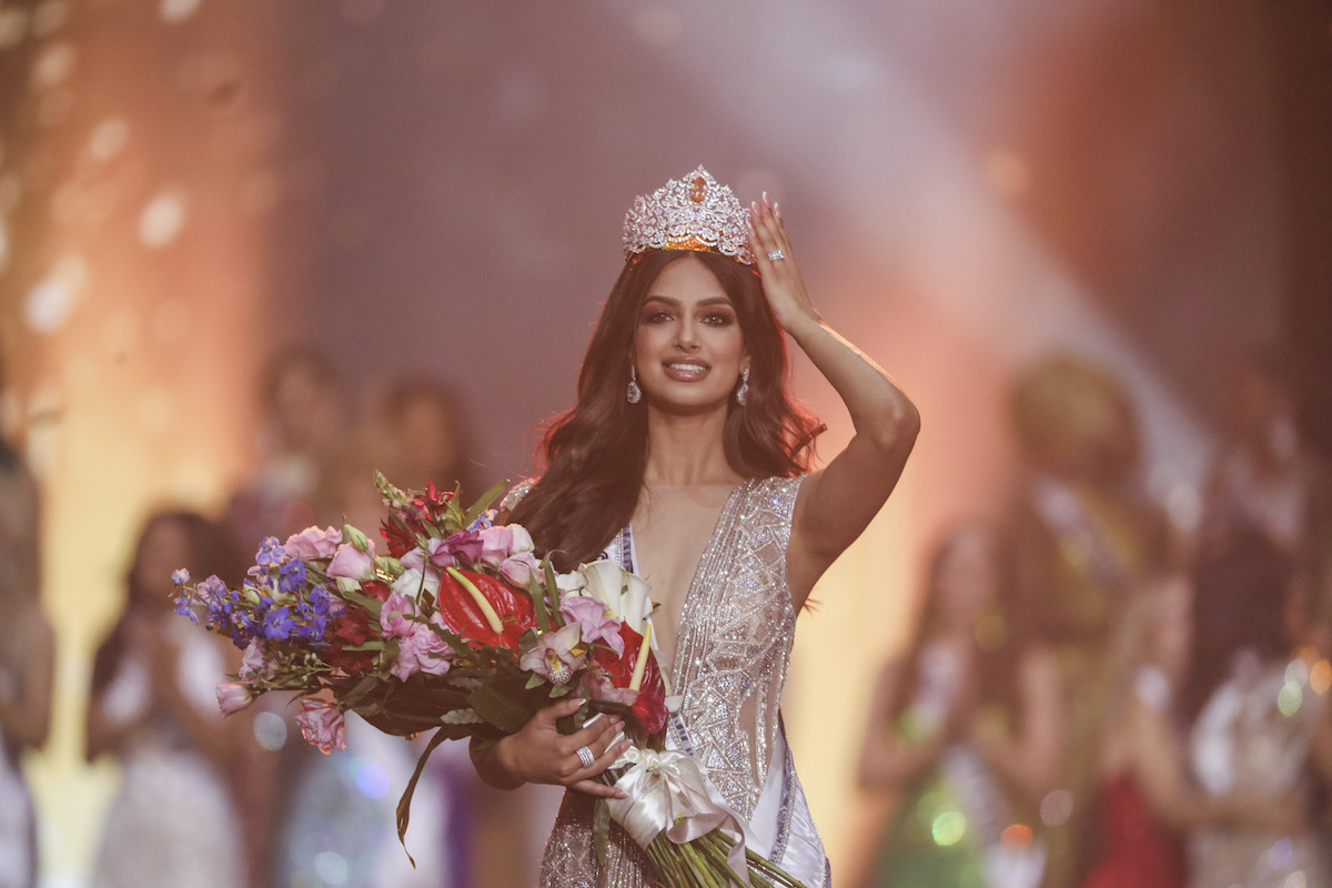 Miss India Harnaaz Sandhu reaches up to touch her crown after winning the 70th Miss Universe pageant