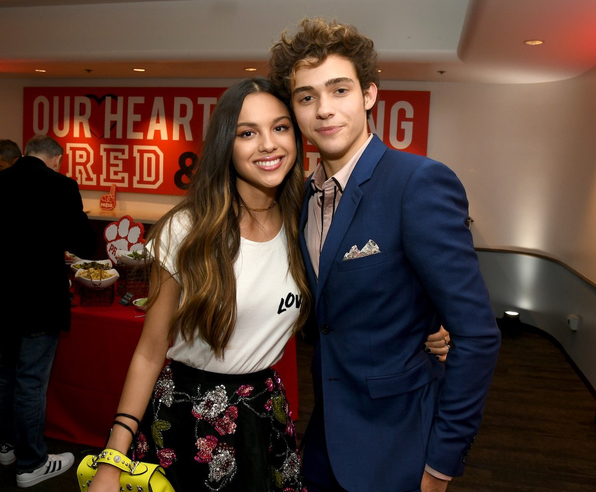 Olivia Rodrigo and Joshua Bassett smile and pose together.