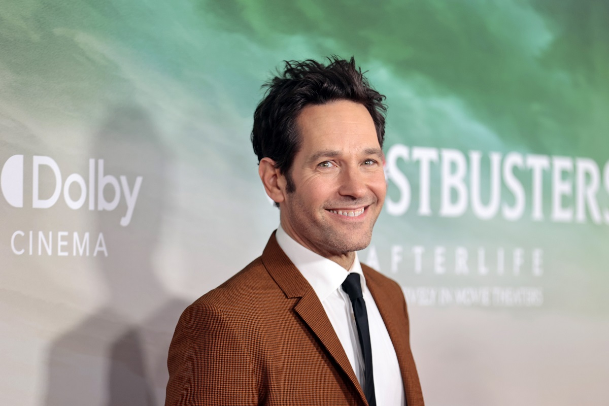 Paul Rudd smiling while wearing a brown suit.