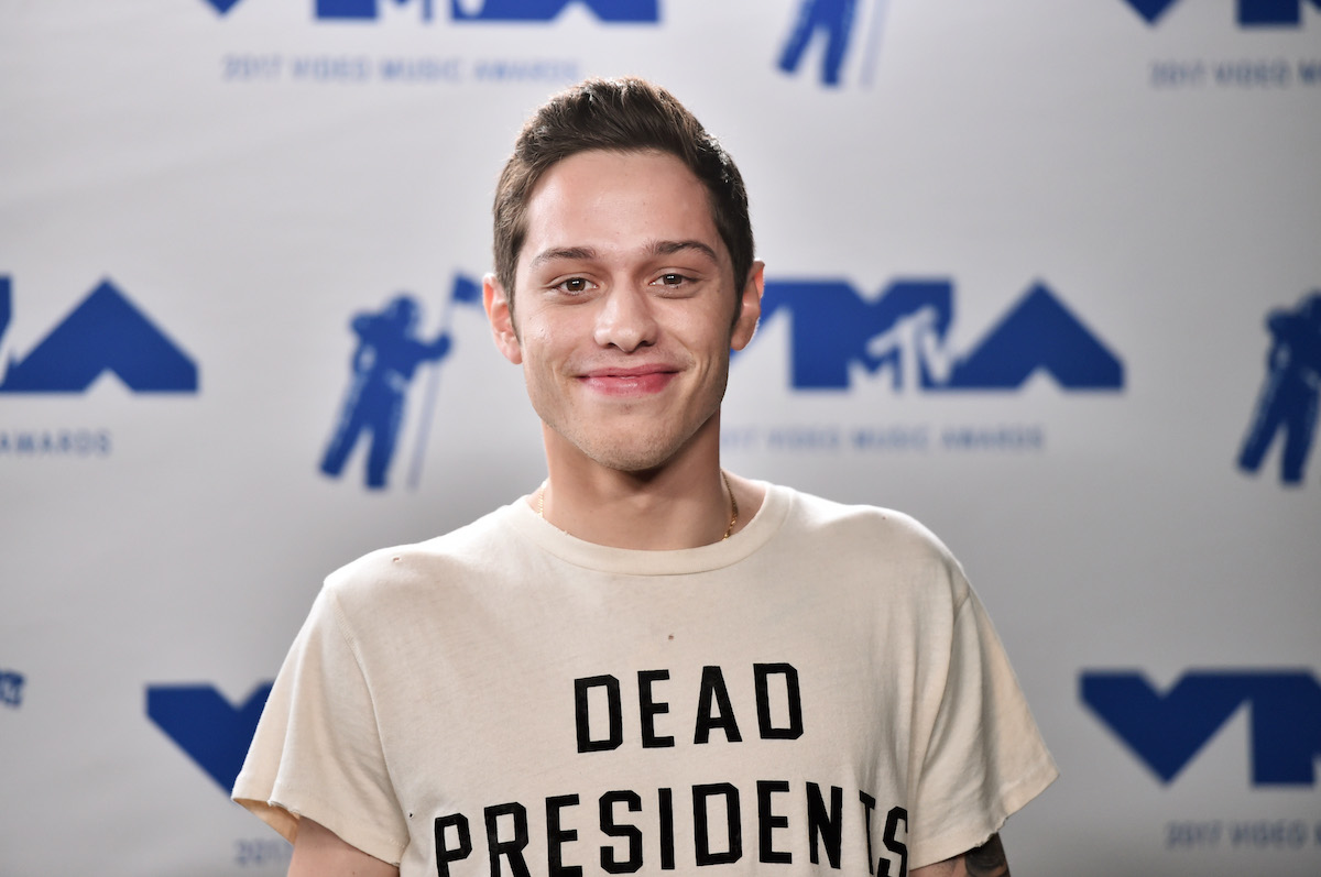 Pete Davidson smiling in front of a white background