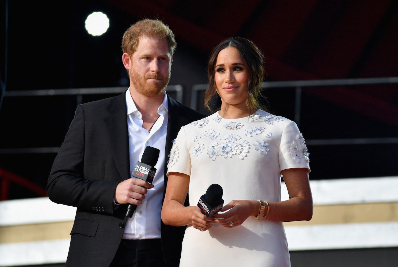 Prince Harry wearing a suit and Meghan Markle wearing a white dress