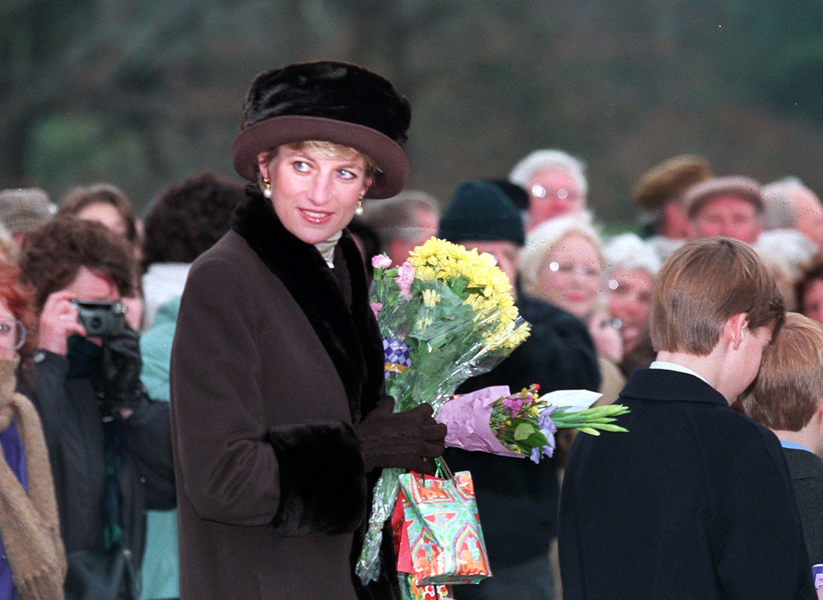 Princess Diana carrying flowers from a wellwisher after attending the Christmas Day service on the Sandringham estate