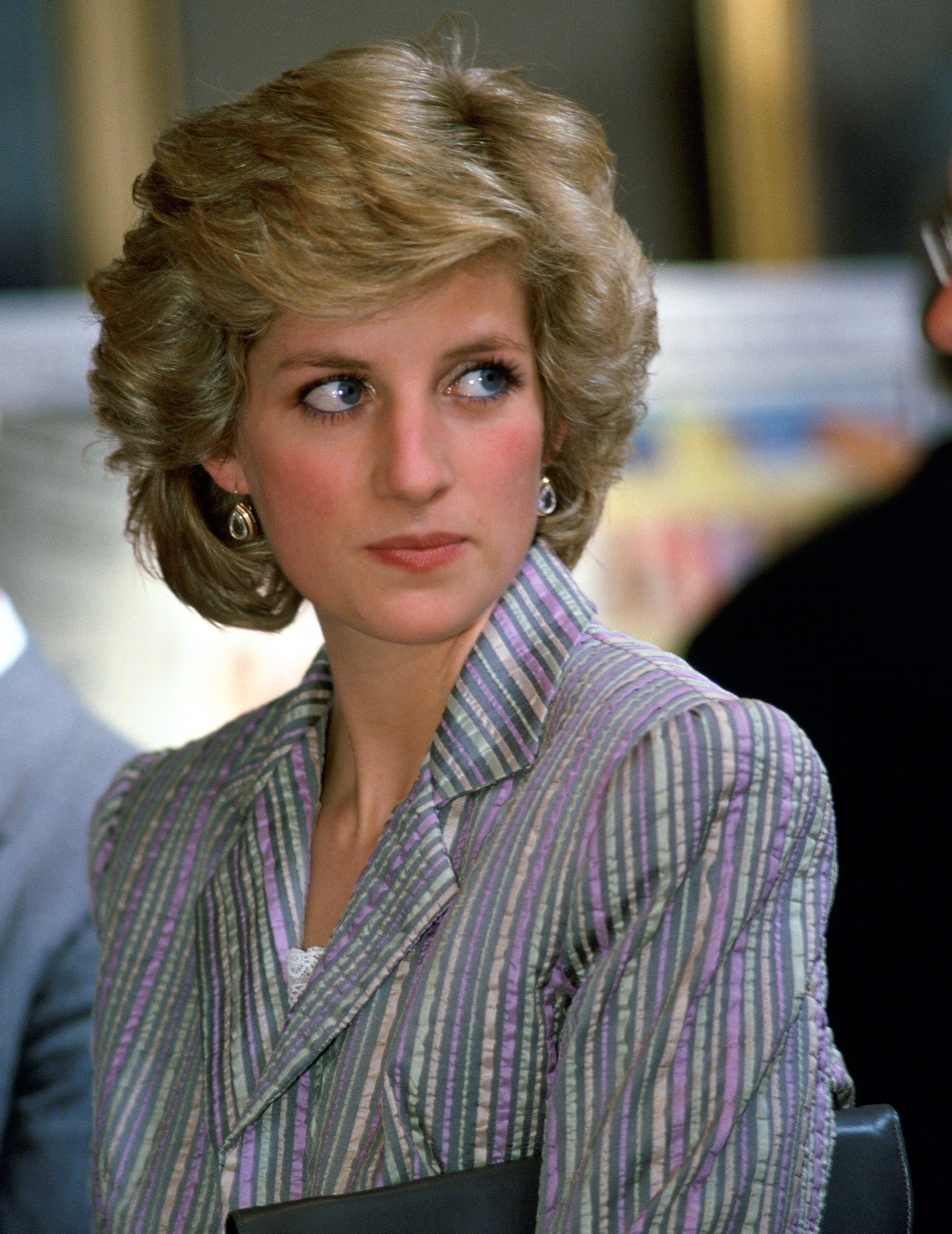 Princess Diana looking on at a royal event in an outfit designed by Bruce Oldfield