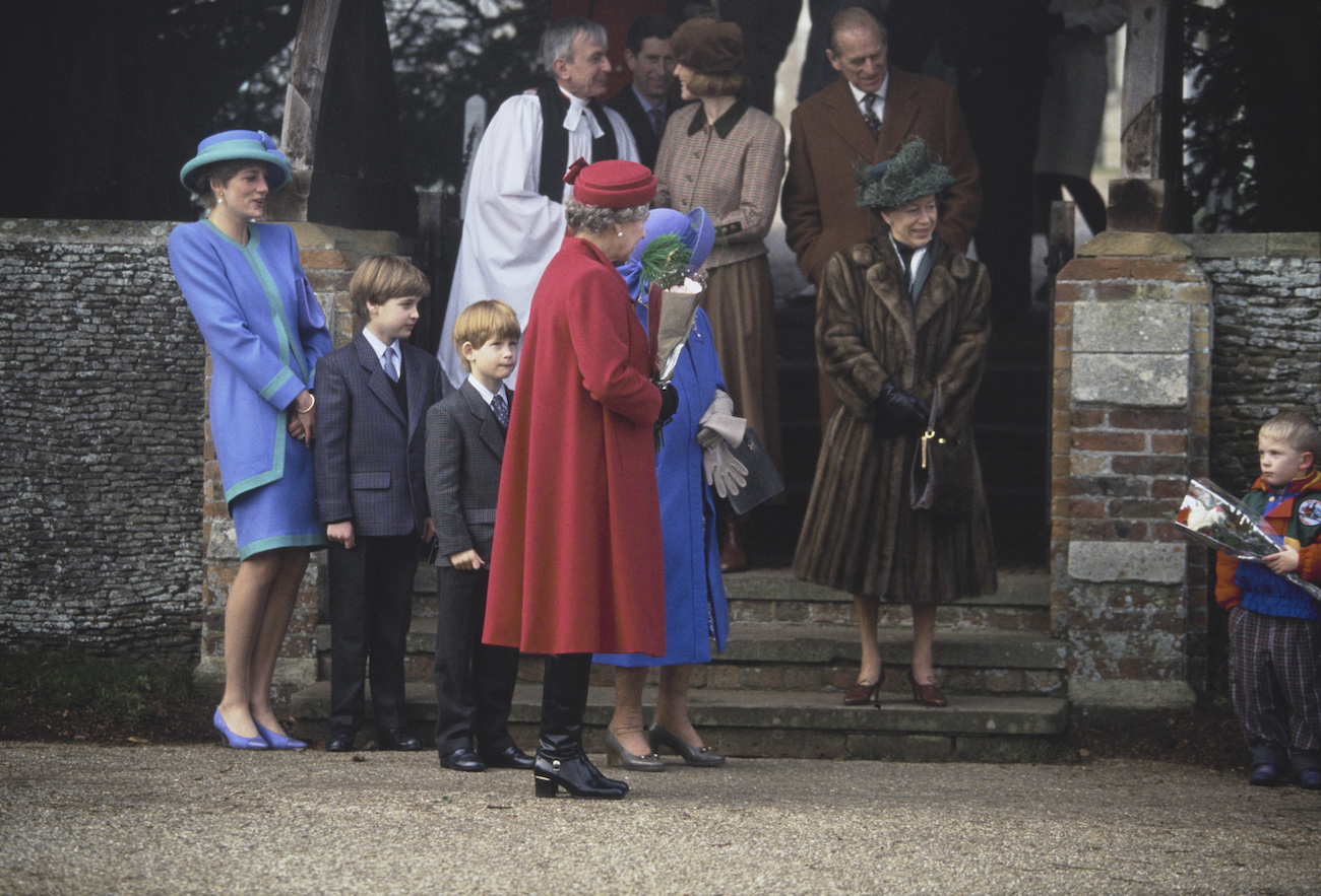 Princess Diana wearing a blue outfit, standing with other royals at Sandringham Estate