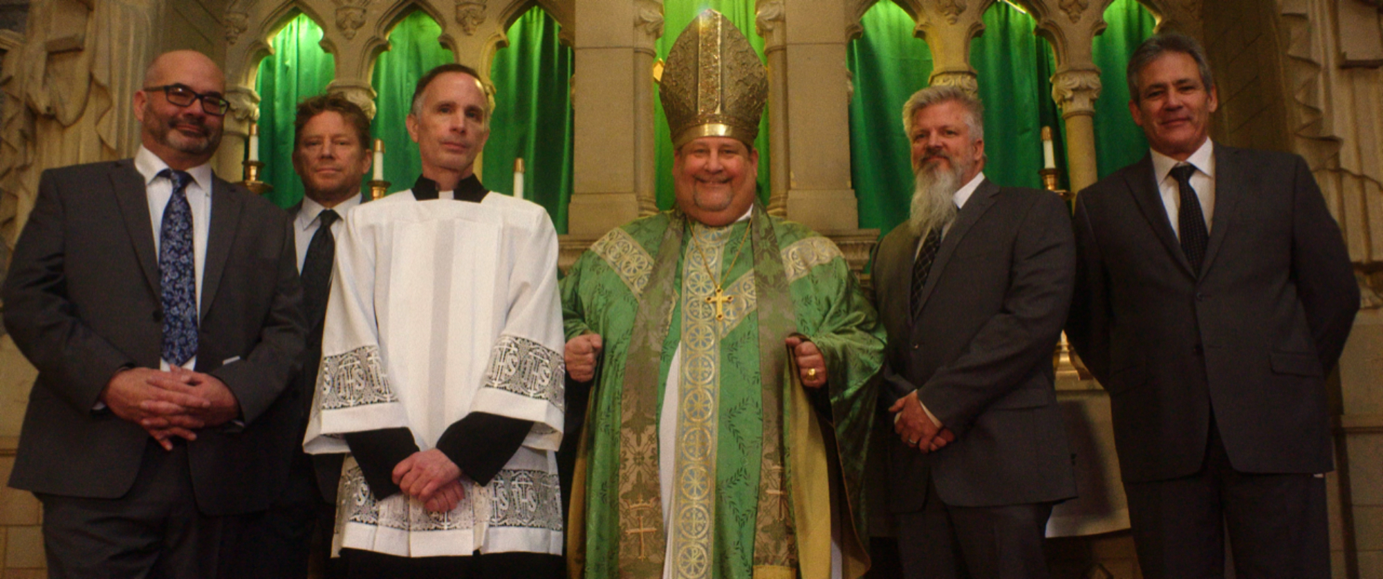 'Procession' Joe Eldred, Ed Gavagan, Michael Sandridge, Tom Viviano, Dan Laurine and Mike Foreman standing in a line inside of a church