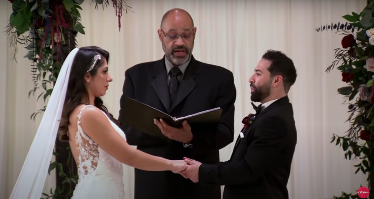 Rachel and Jose from 'Married at First Sight' Season 13 holding hands at the altar on their wedding day