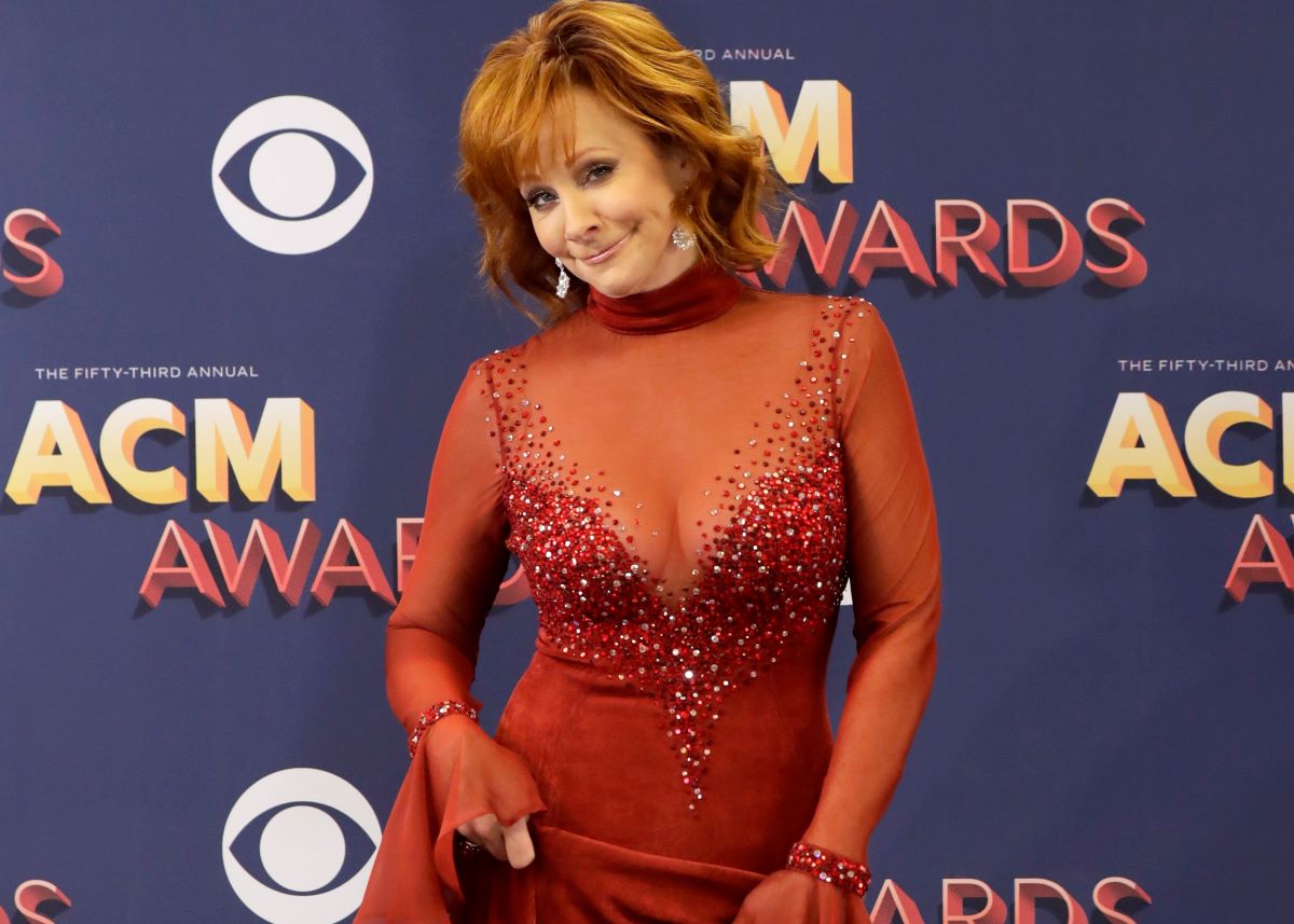 Reba McEntire in a low-cut red dress, smiling