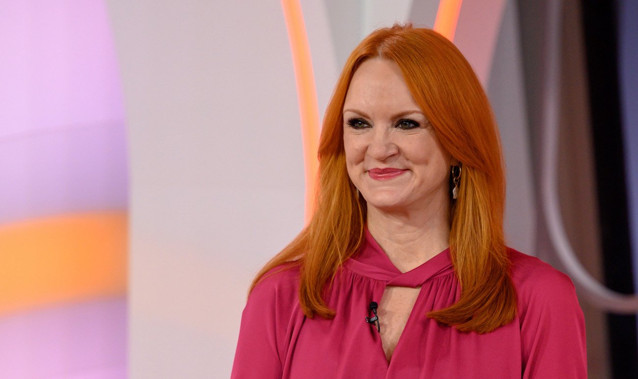 Ree Drummond smiles and looks on wearing a pink top