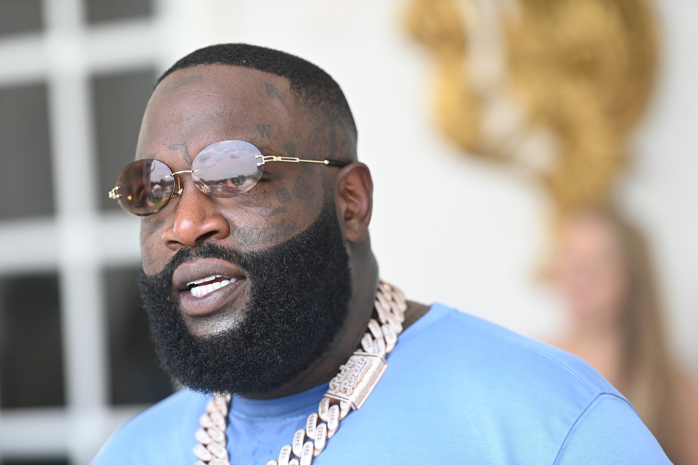Rick Ross wearing a blue shirt and chain
