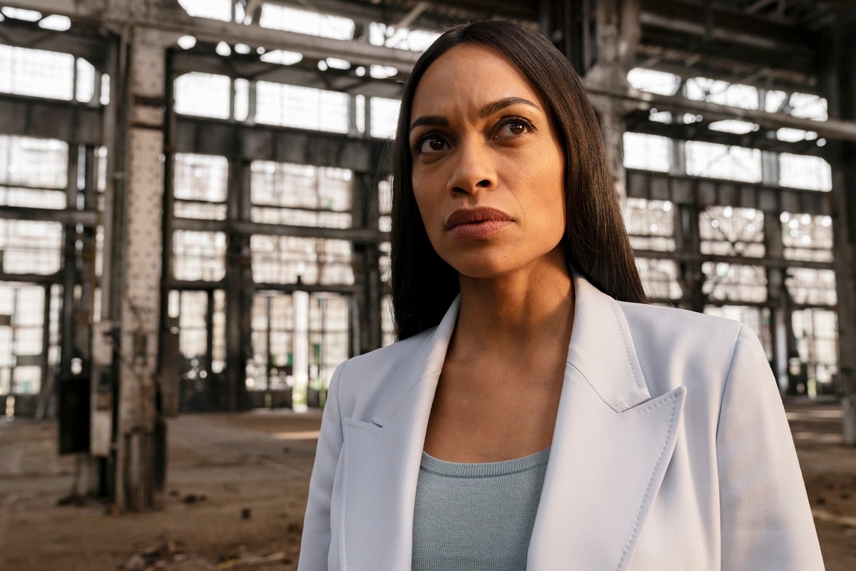 Rosario Dawson posing in a white suit.