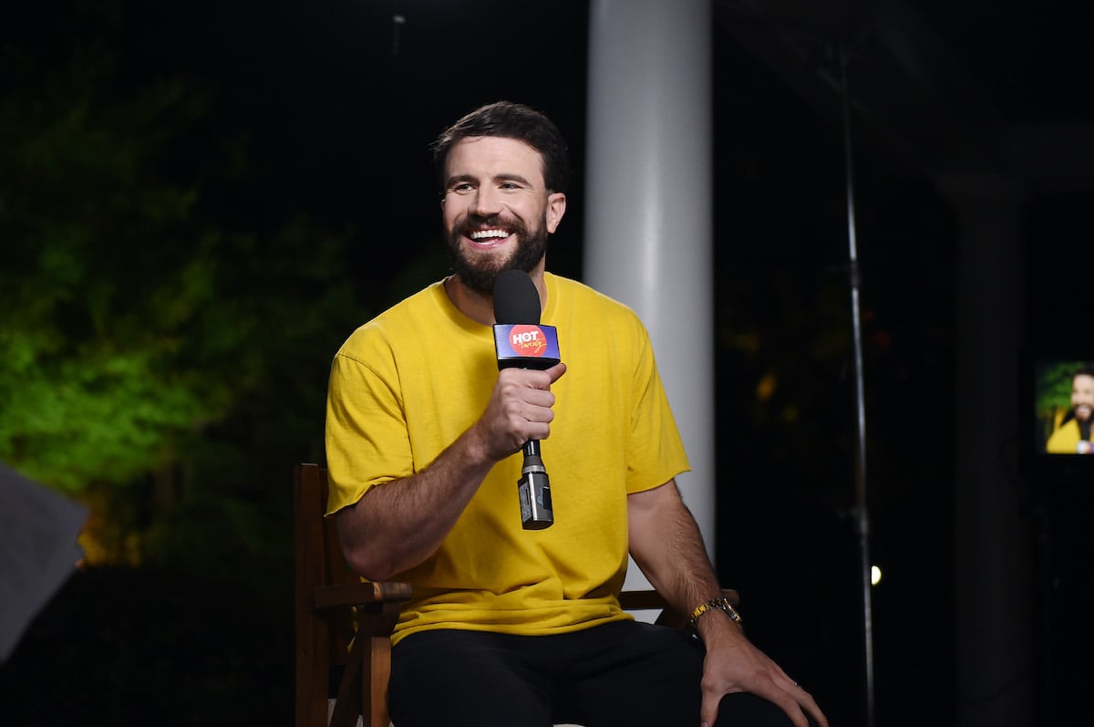 Sam Hunt smiling, holding a microphone
