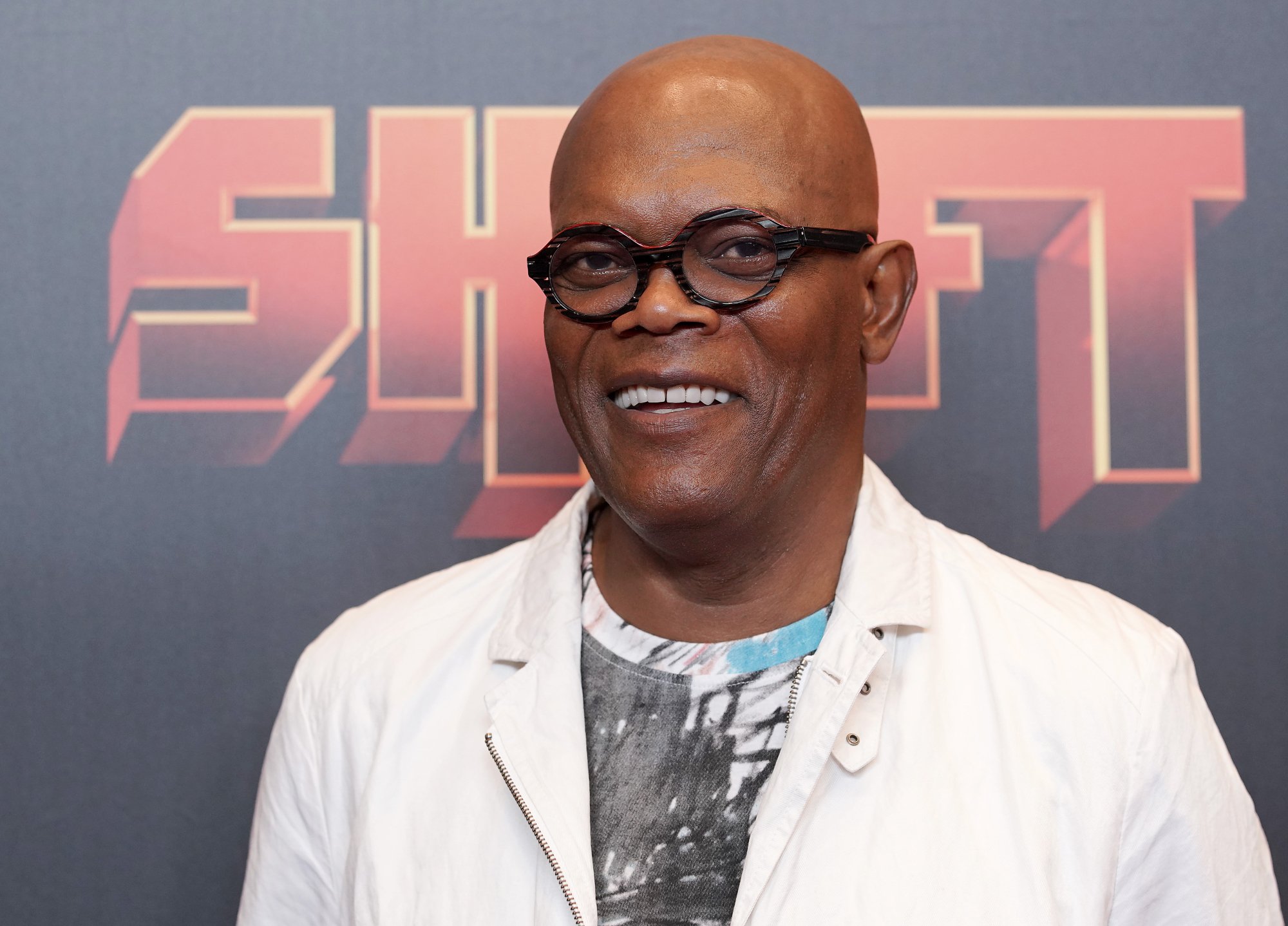 Samuel L. Jackson movies smiling wearing glasses and a white jacket