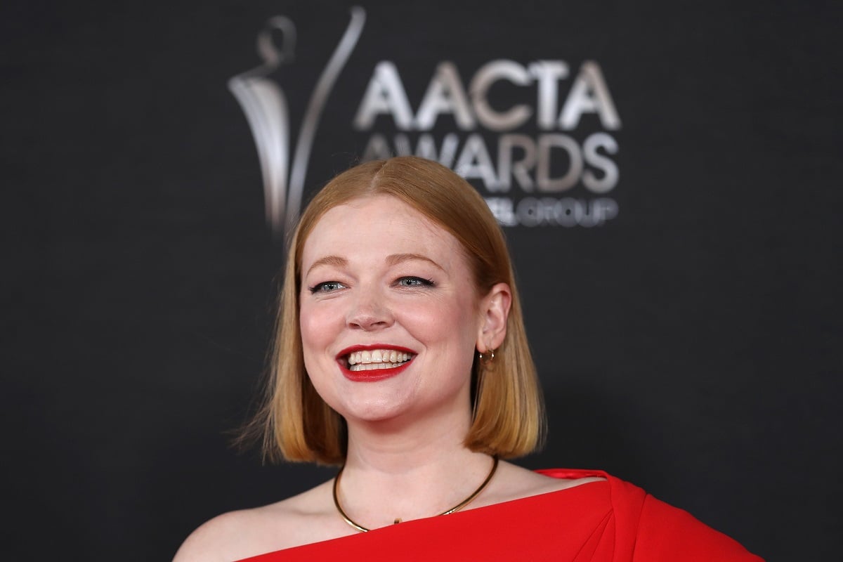 Sarah Snook smiling in a red dress.