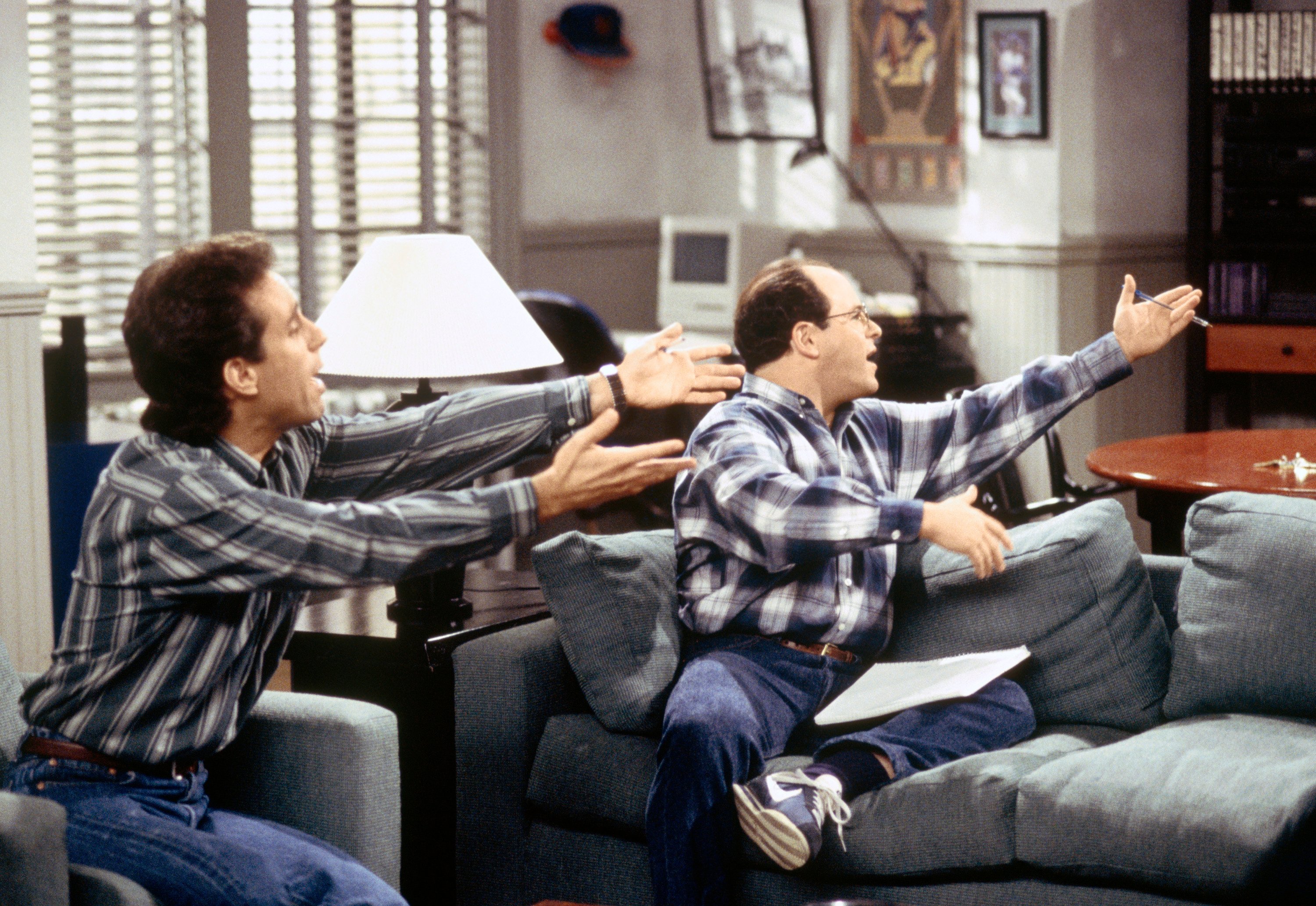 Jerry Seinfeld and George Costanza sit in Jerry's apartment in an episode of 'Seinfeld'