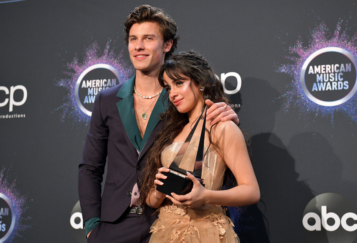 Shawn Mendes and Camila Cabello pose together holding an award.