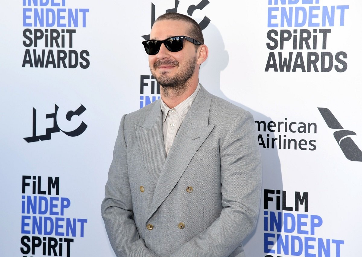 Shia LaBeouf smiling while wearing sunglasses.