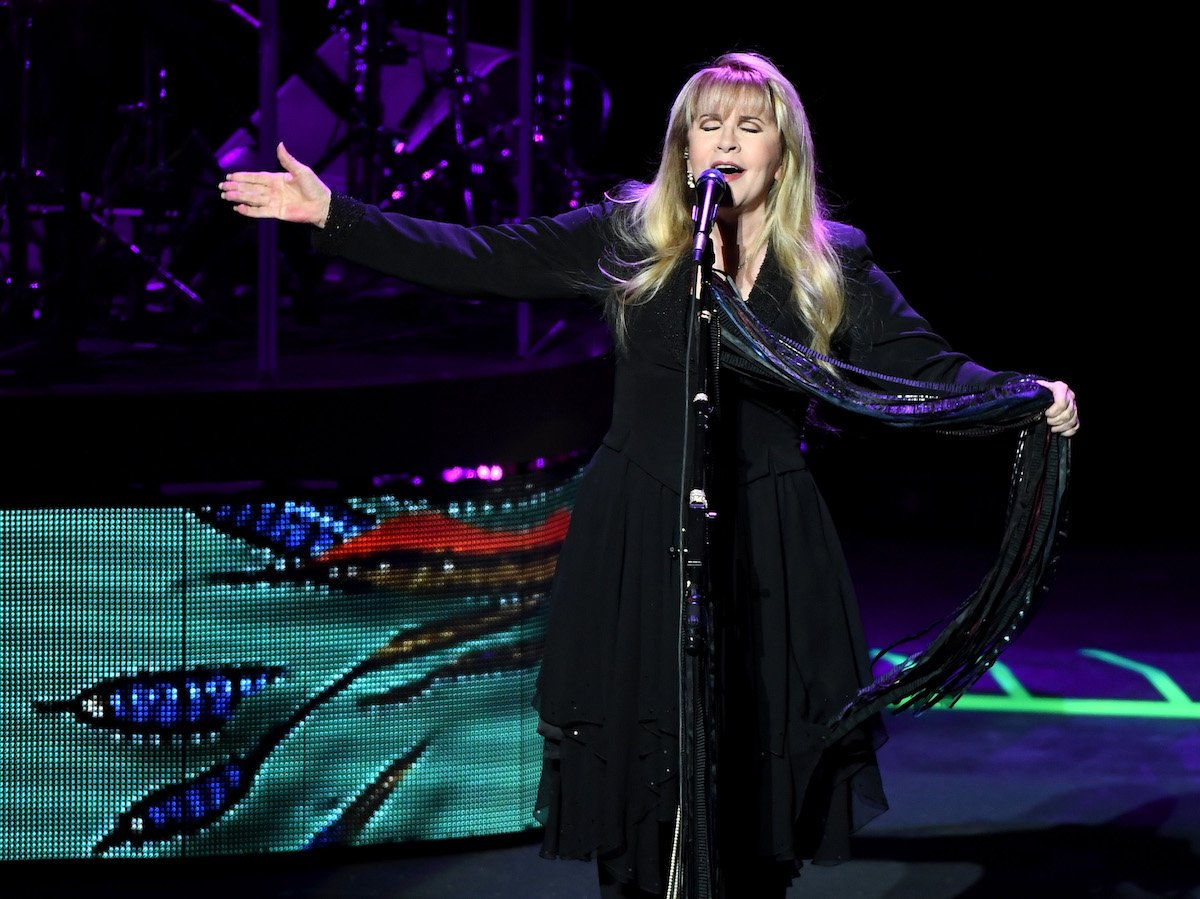 Stevie Nicks sings into a microphone.