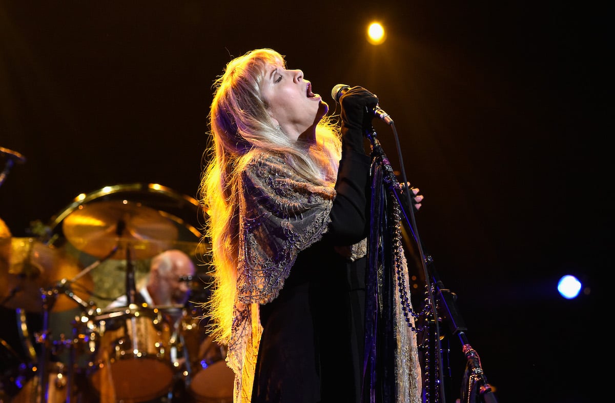 Stevie Nicks sings into a microphone.