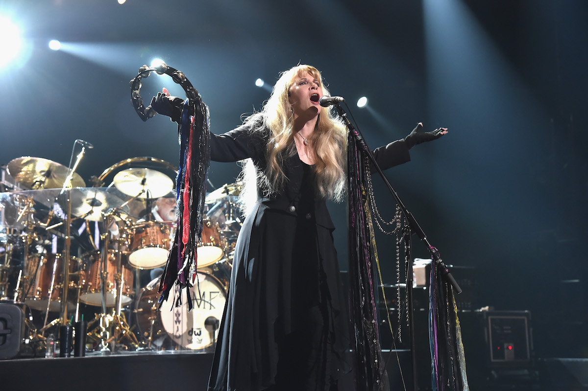 Stevie Nicks performs with a tambourine.