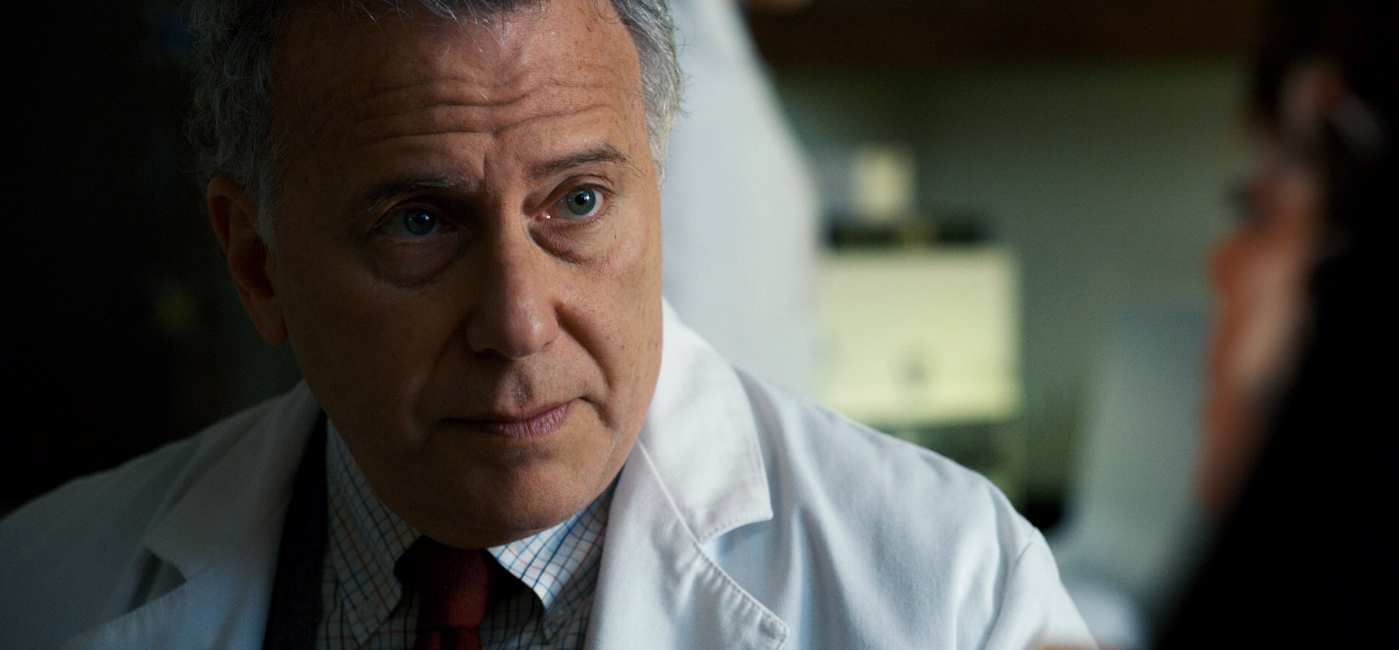 Paul Reiser wearing a lab coat in a scene from 'Stranger Things' Season 2