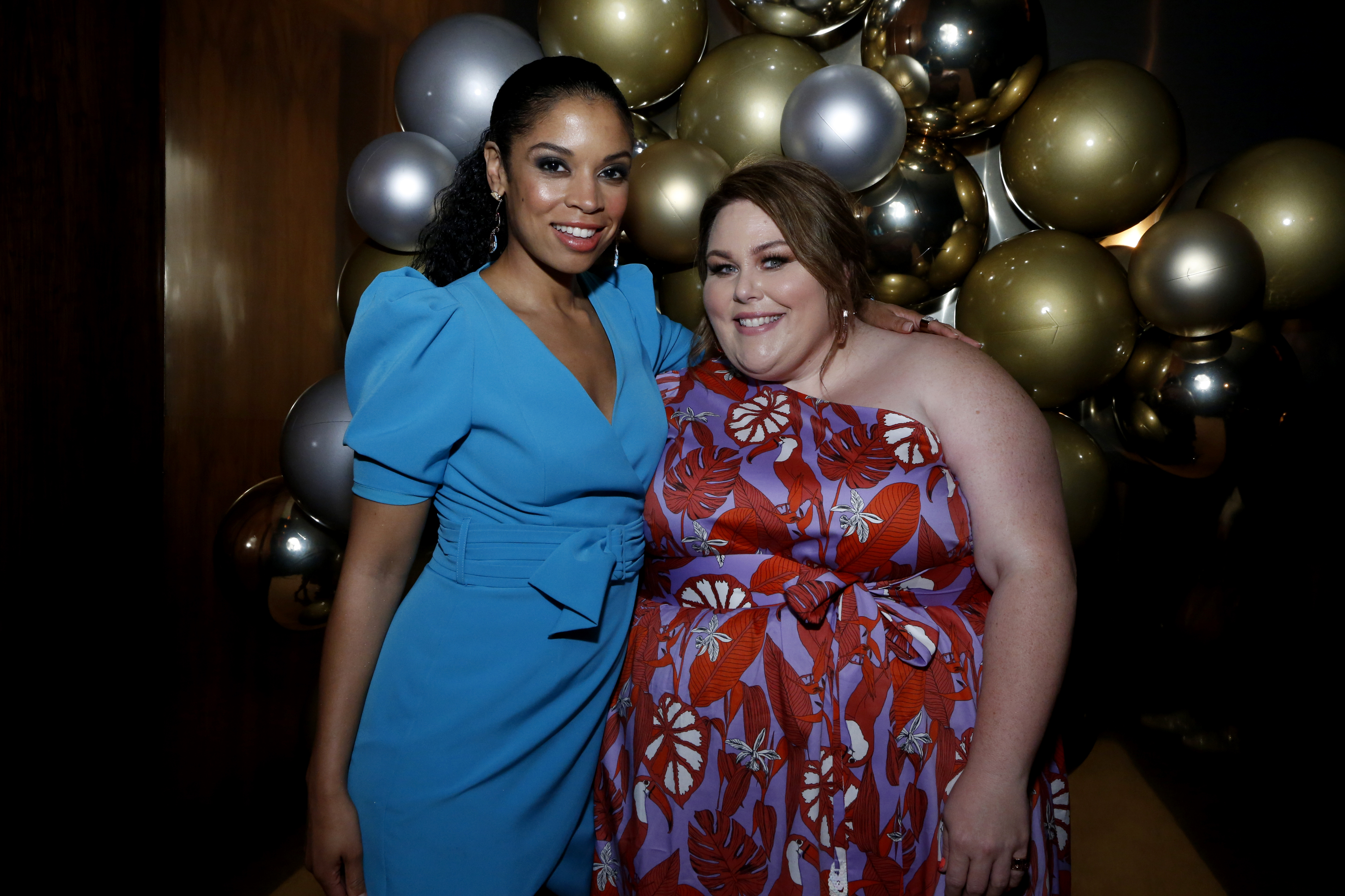 Susan Kelechi Watson, in a blue dress, with her arm around Chrissy Metz
