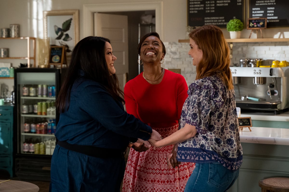 Dana Sue, Helen, and Maddie smiling and holding hands in 'Sweet Magnolias' Season 2 