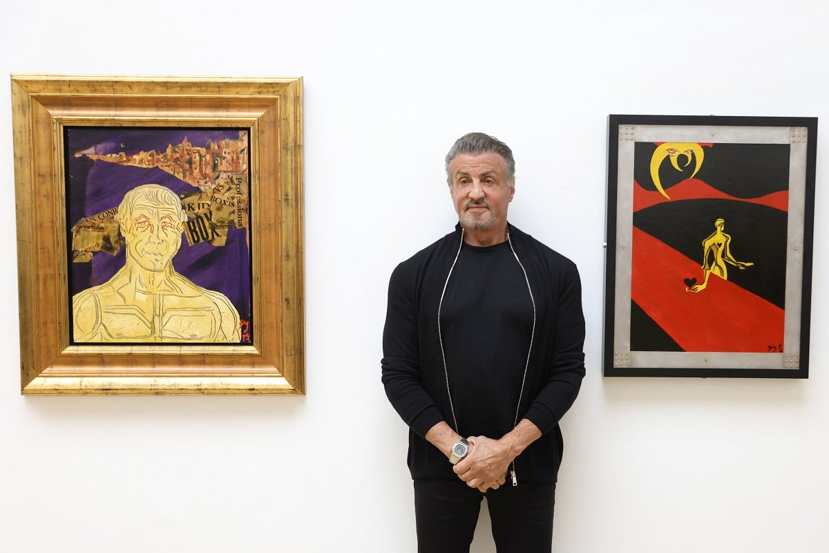 Sylvester Stallone posing in a black sweater.