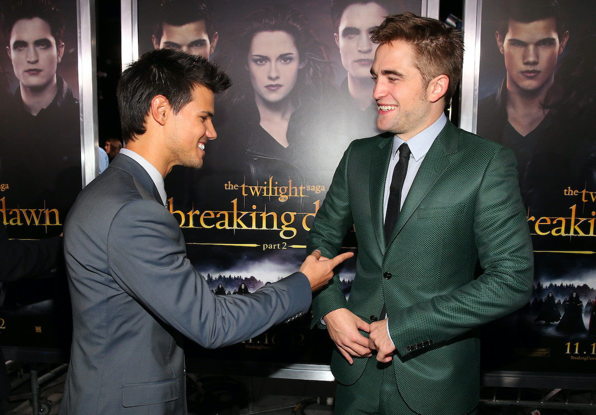 Twilight actors Taylor Lautner and Robert Pattinson laugh on the red carpet