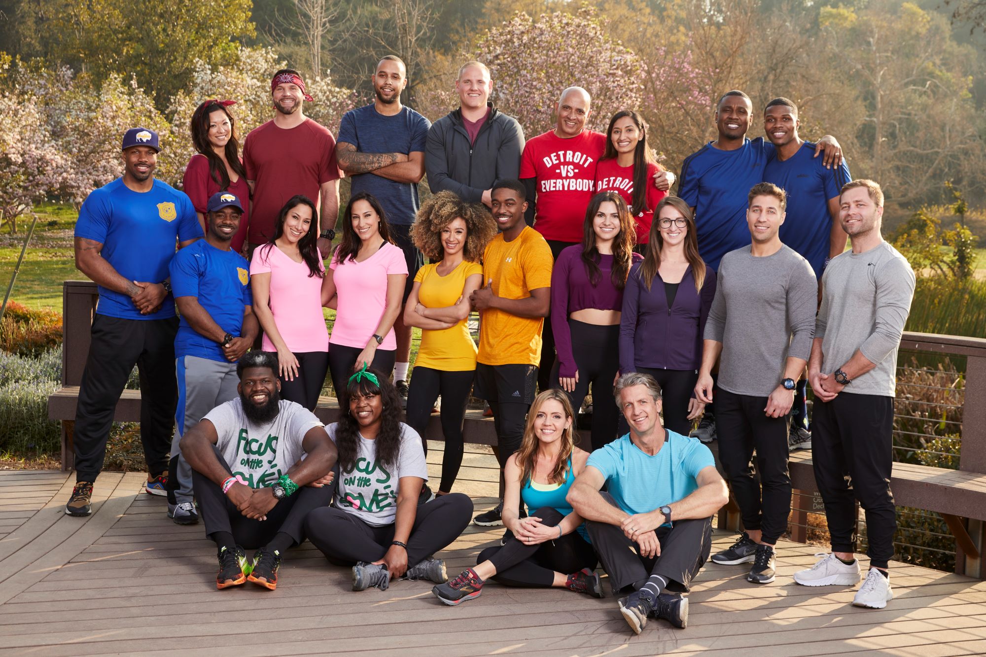 The cast of 'The Amazing Race' Season 33 pose together for promotional photos in a park, and all 22 contestants are in their race gear.