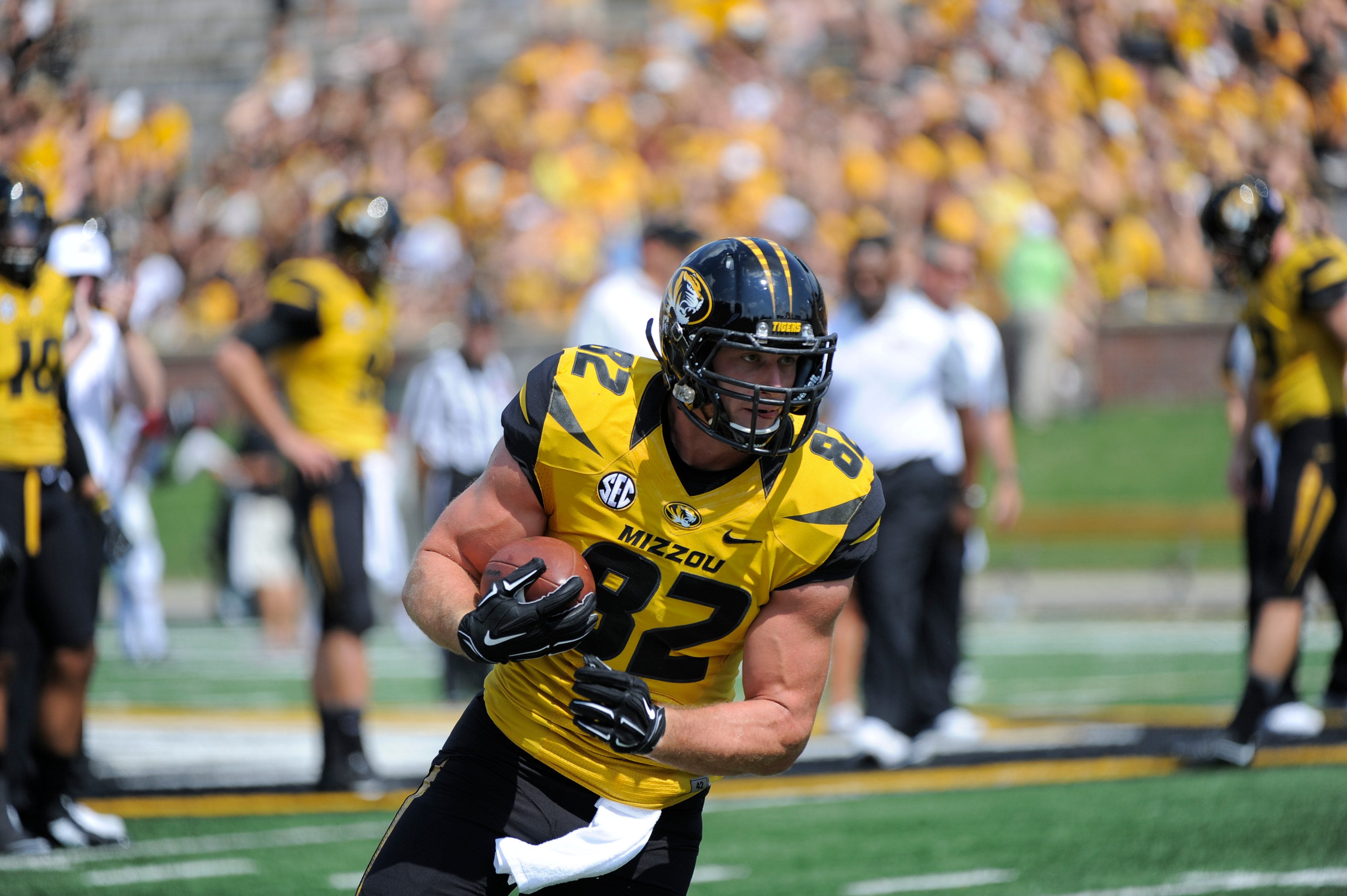 The next bachelor is Clayton Echard. Clayton runs with a football under his arm, in his MU uniform, while warming up for a game.