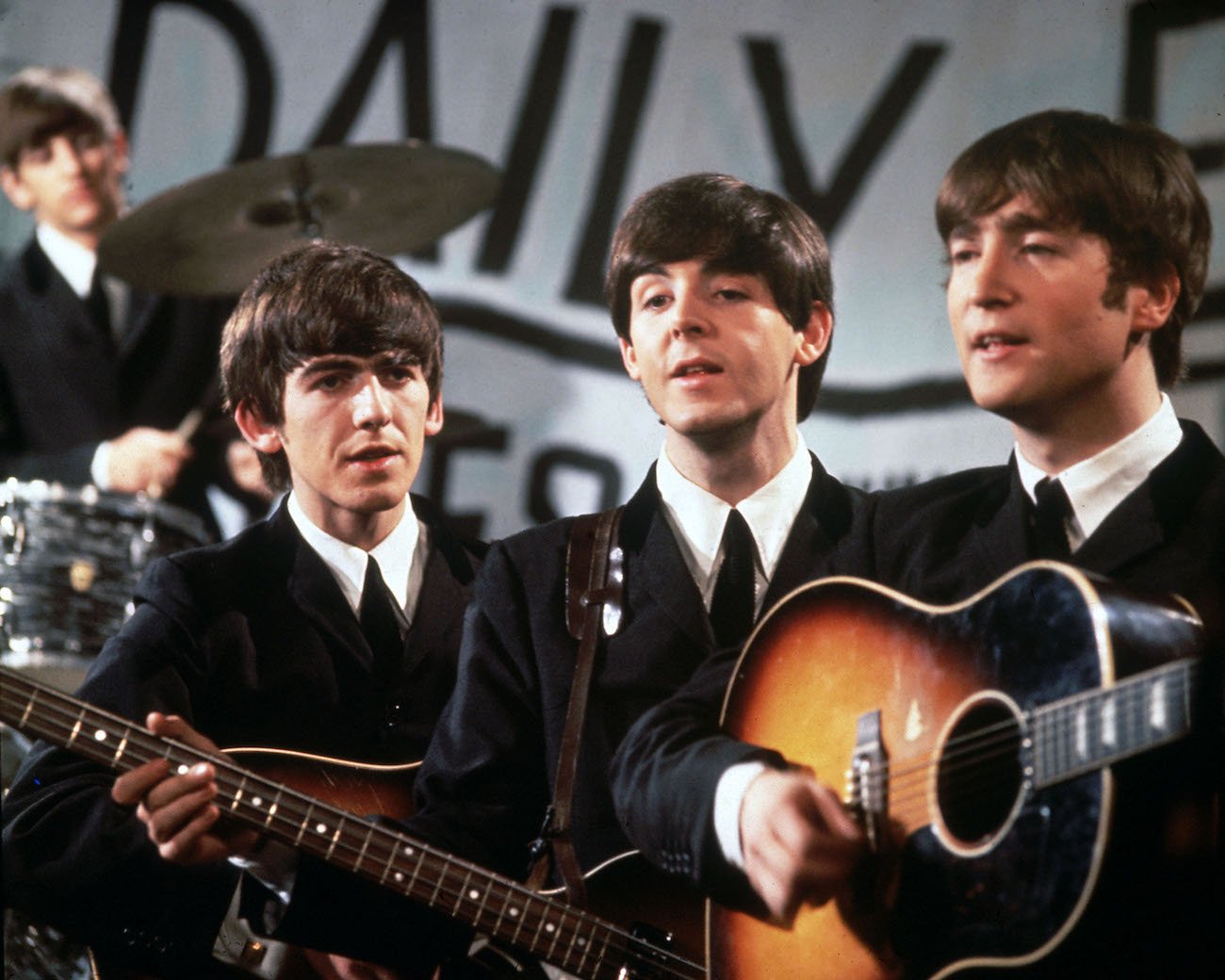 The Beatles performing in suits in 1963.