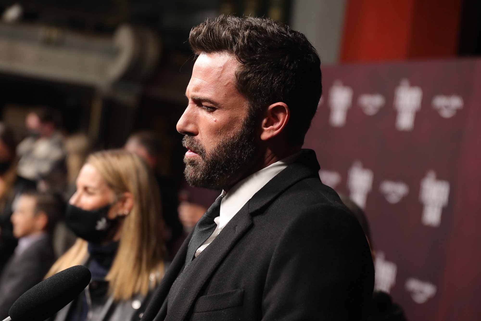 'The Last Duel' actor Ben Affleck talking with a microphone in front of him on the red carpet