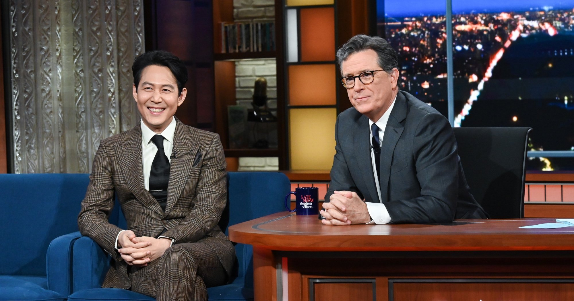 'The Late Show with Stephen Colbert' and guest Lee Jung-Jae wearing a suit and tie on set.