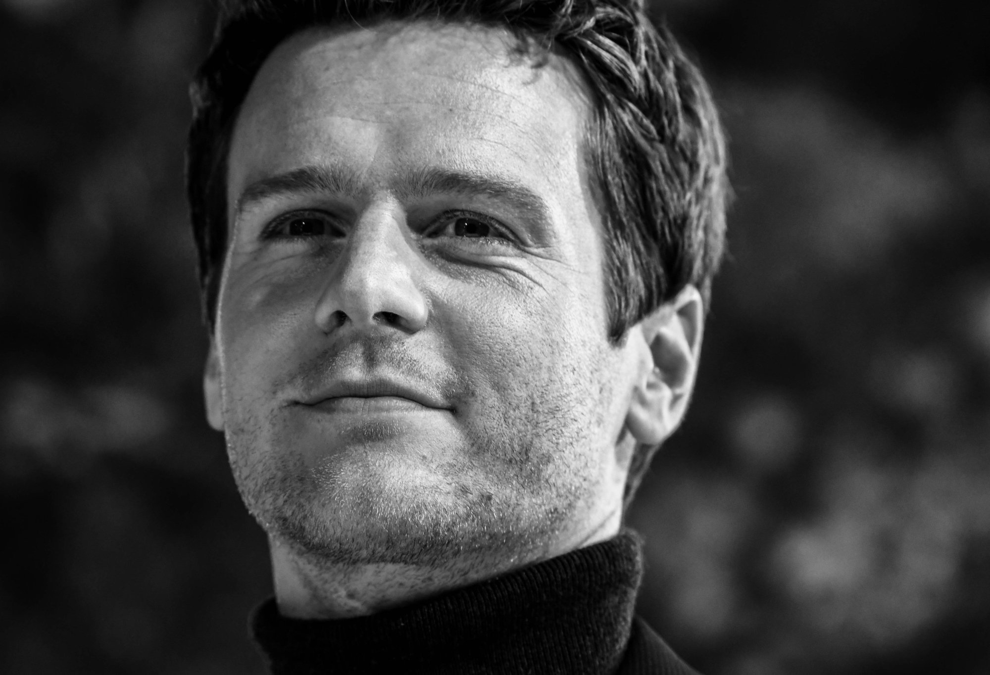 'The Matrix Resurrections' Jonathan Groff with a closed-mouth smile in black-and-white