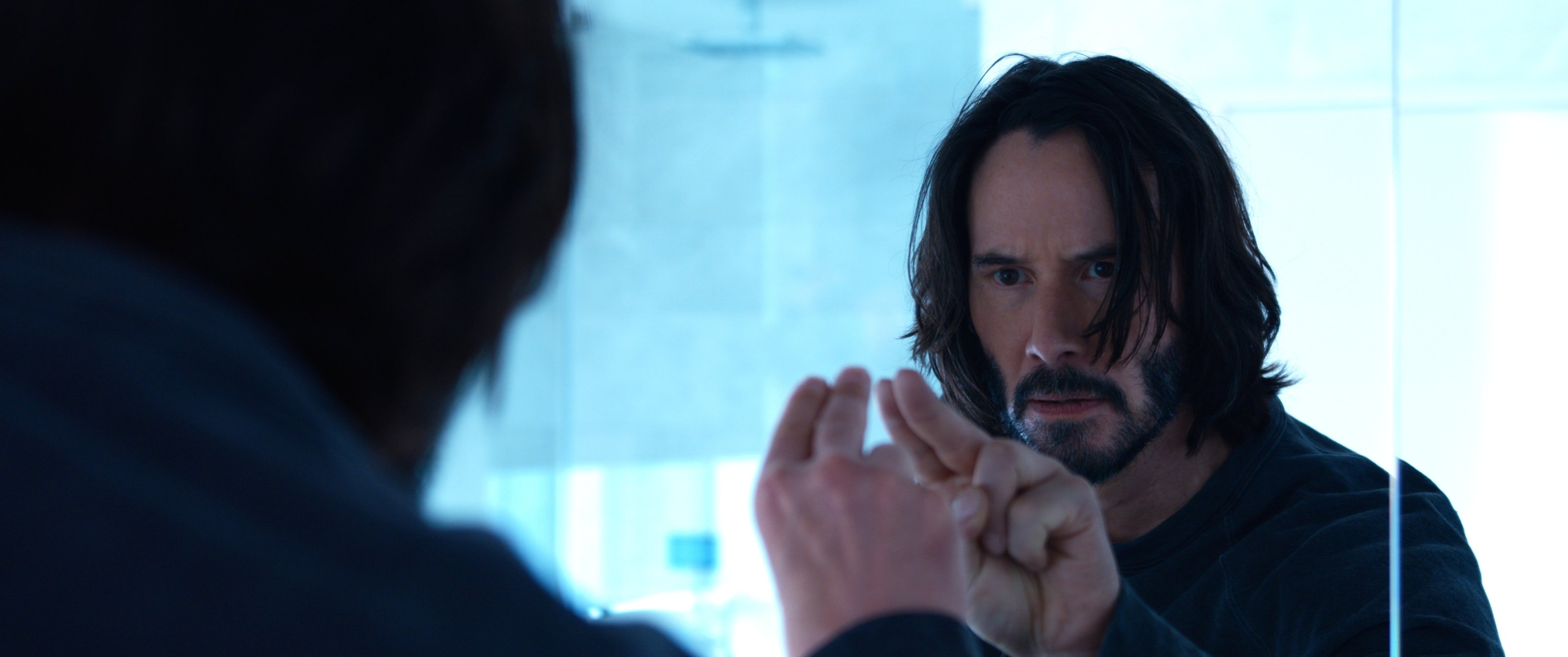 'The Matrix Resurrections' Keanu Reeves as Neo, Thomas A. Anderson poking his fingers toward a mirror