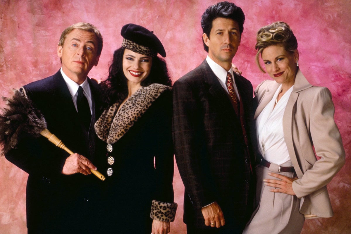 'The Nanny' main cast posing in front of a pink background