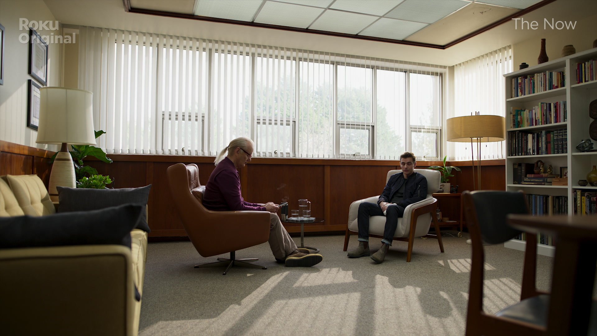 Bill Murray sits in a chair across from Dave Franco in a still from the new Roku Original series called 'The Now'