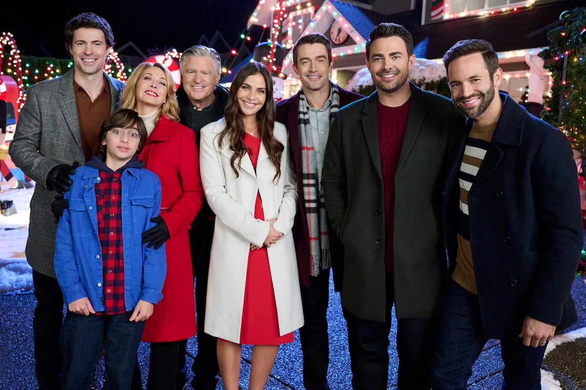 The Mitchell family standing in front of a house decorate for the holidays in 'The Christmas House 2: Deck Those Halls'