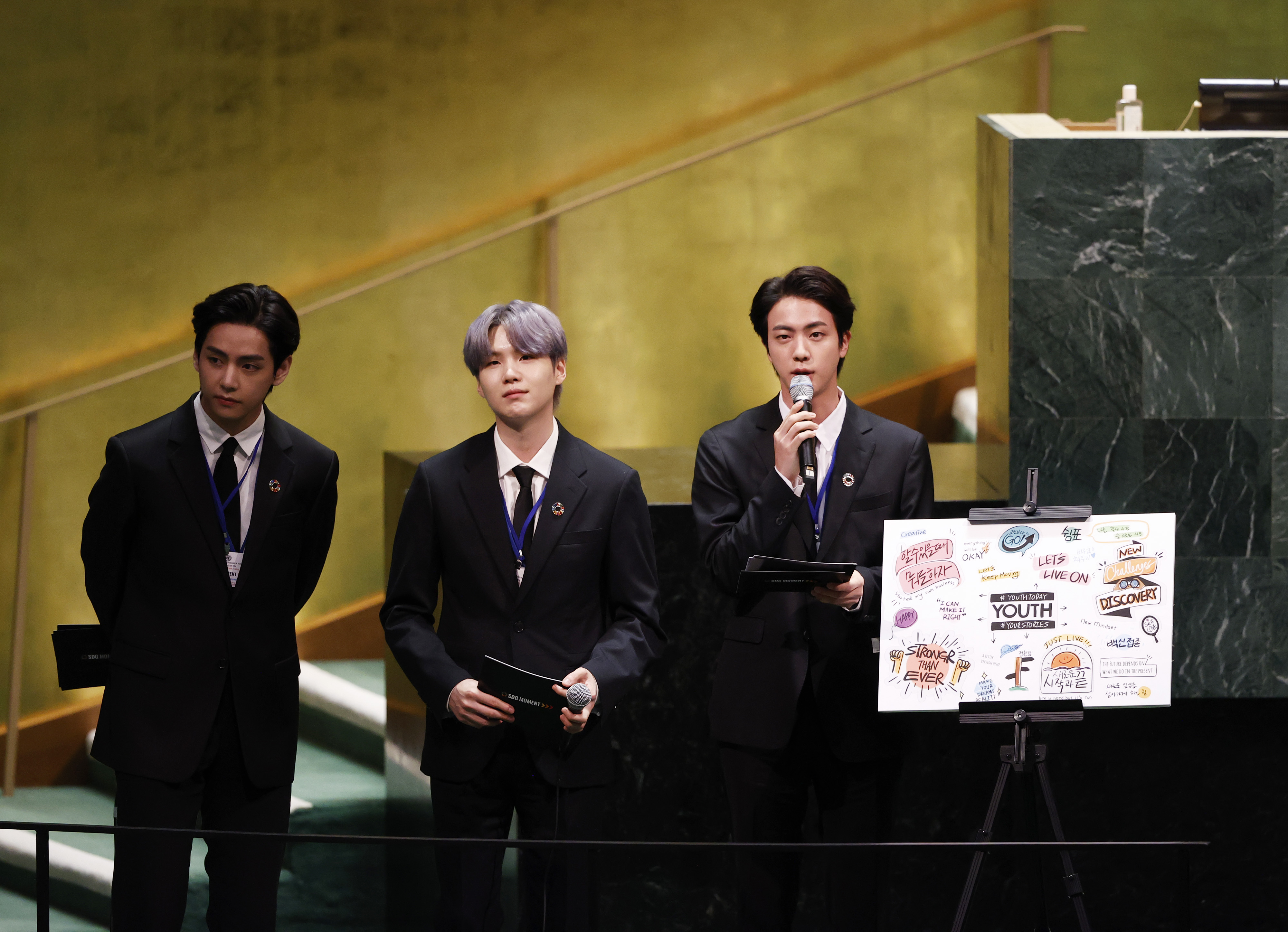 Taehyung/V, Suga, and Jin of South Korean boy band BTS take turns speaking at the SDG Moment event as part of the UN General Assembly 76th session General Debate in UN General Assembly Hall
