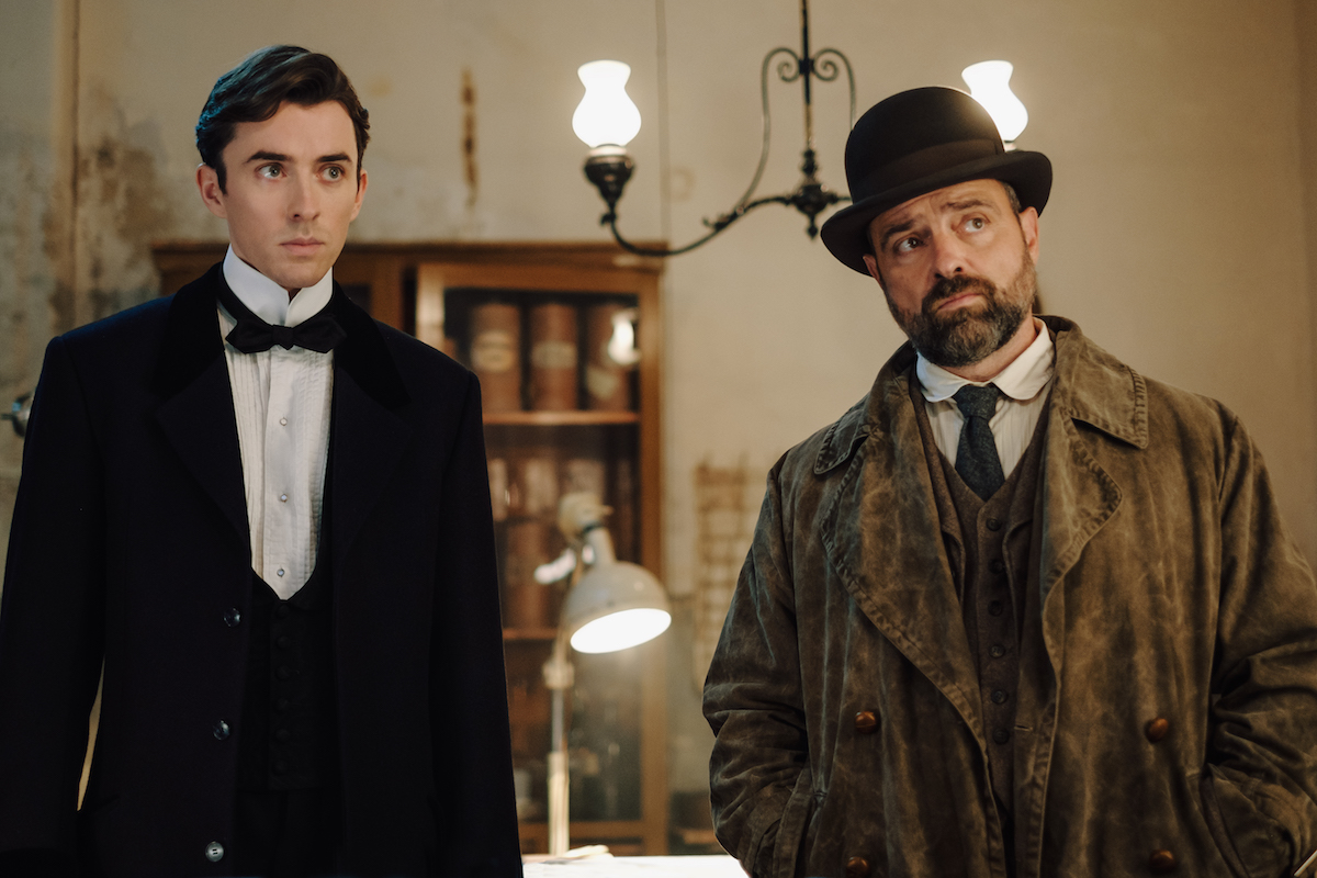 Matthew Beard in a suit and Juergen Maurer in coat and hat in 'Vienna Blood' Season 2
