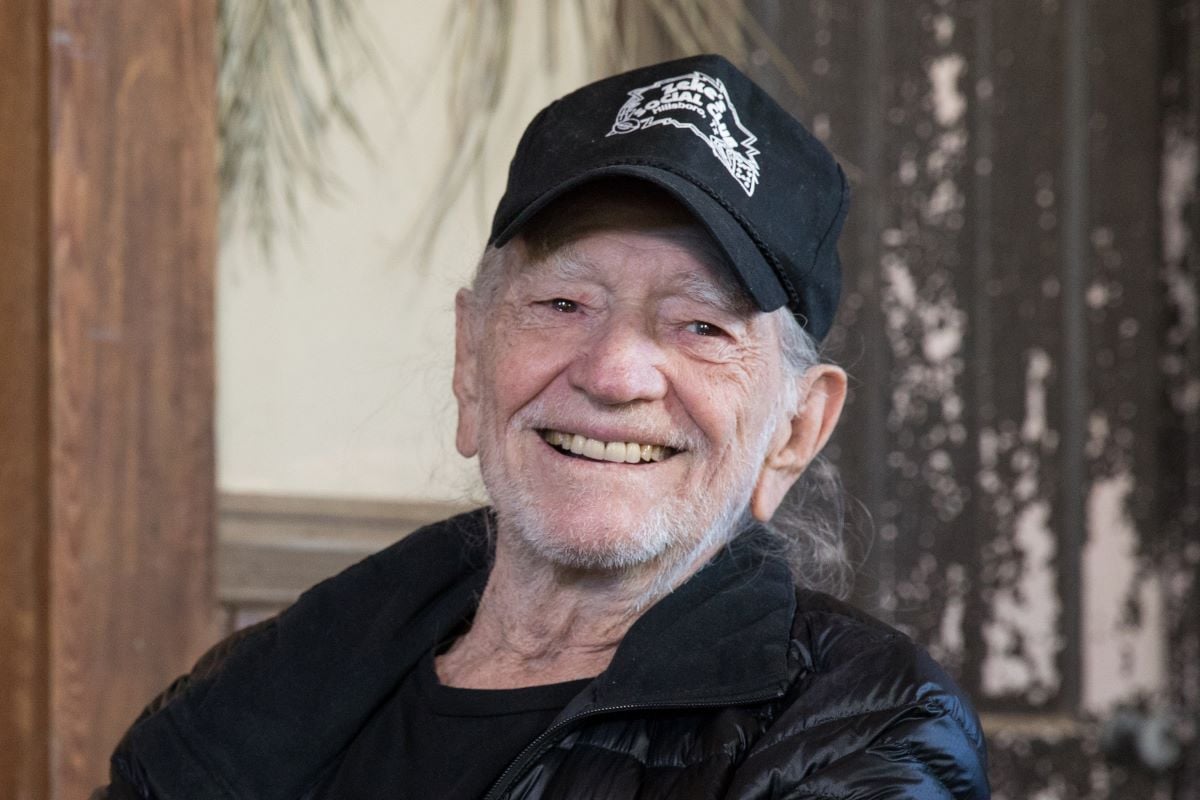 Smiling Willie Nelson in a black hat