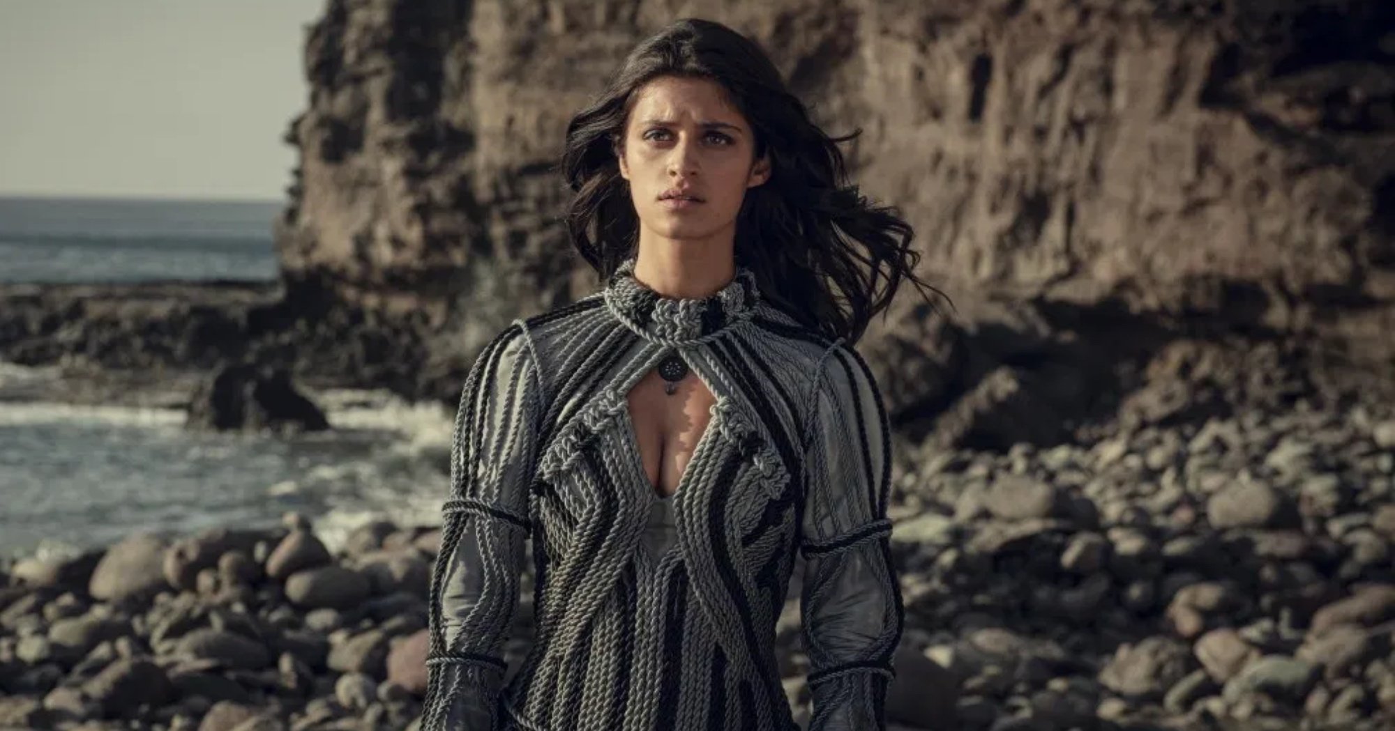 Yennefer from 'The Witcher' Season 1 still by a cliff and beach.