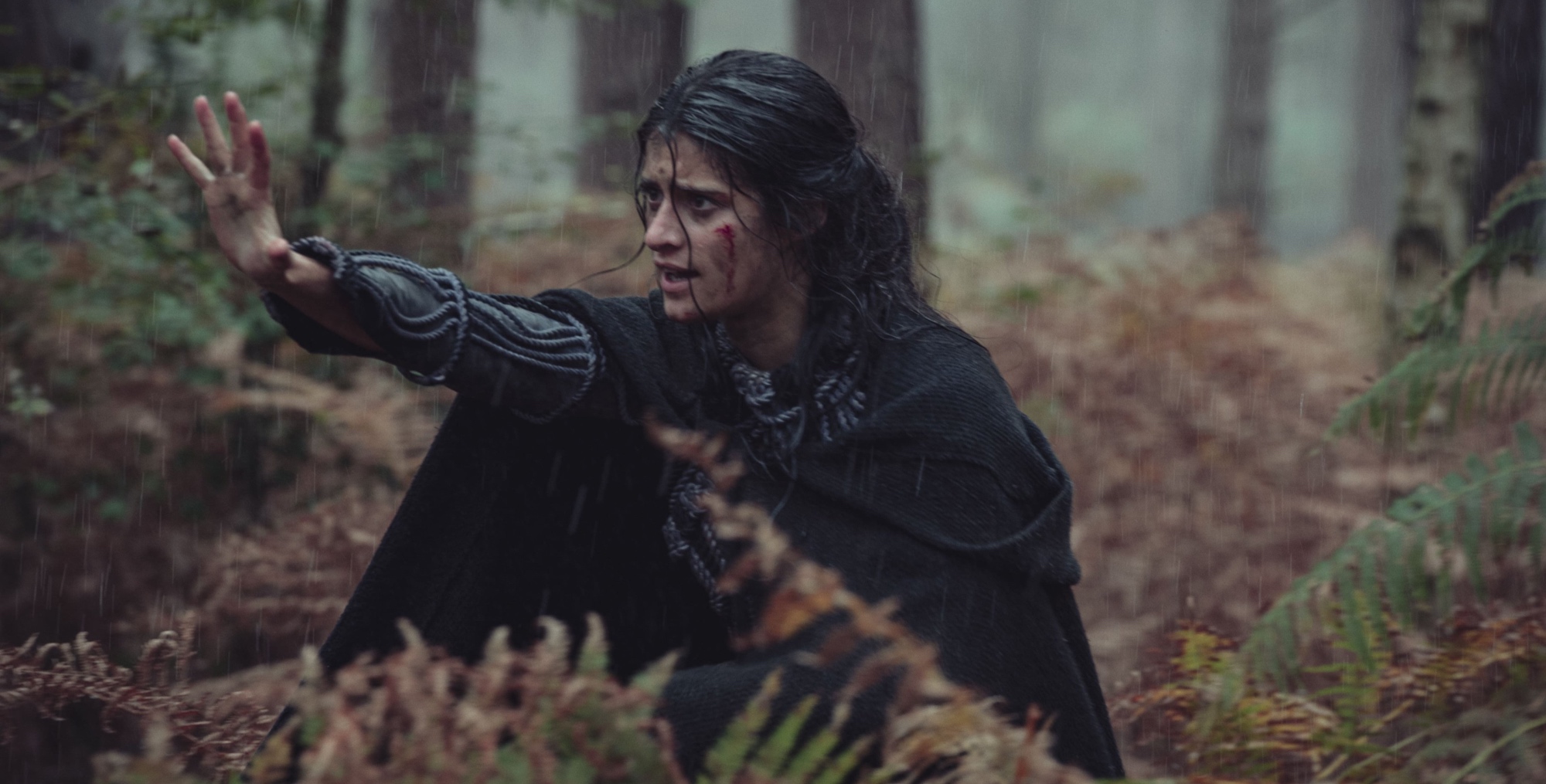 Yennefer in 'The Witcher' Season 2 in the rainy forest wearing cloak.
