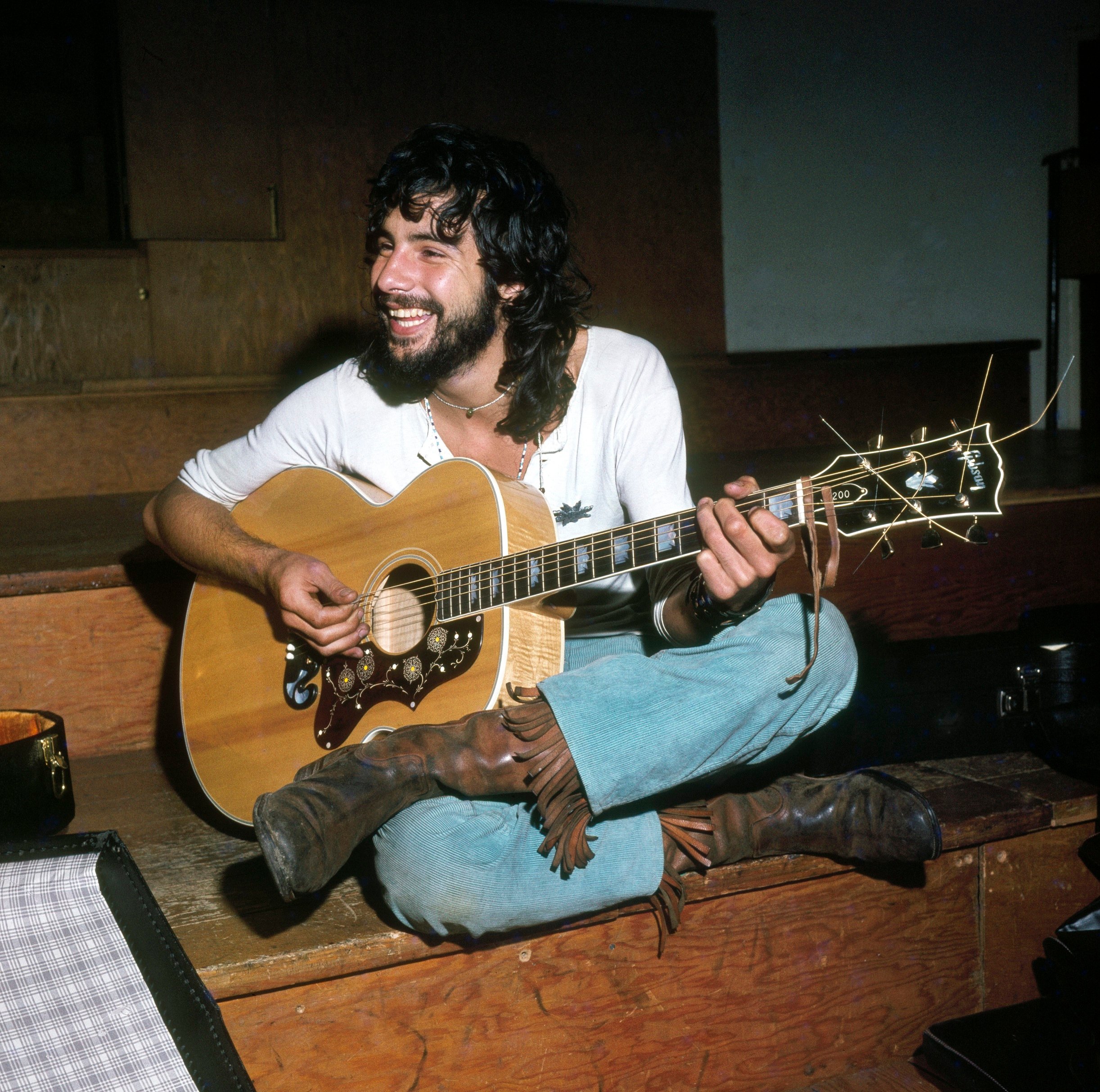 Cat Stevens playing songs on a guitar