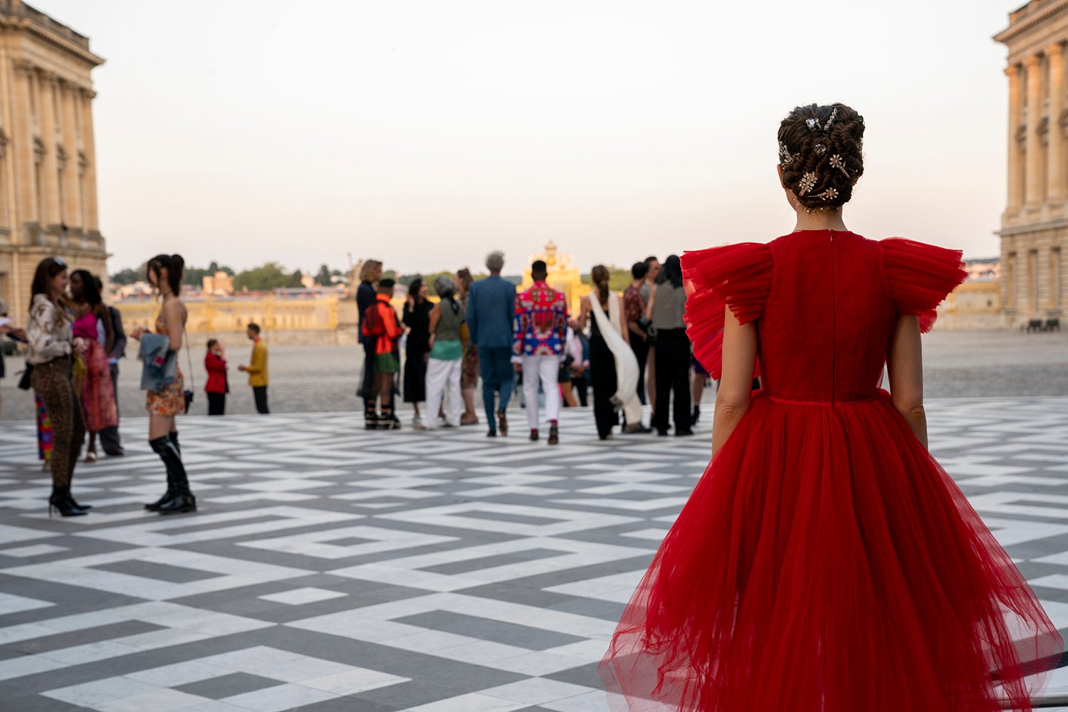 Lily Collins as Emily walking away from the camera in a red dress in Emily in Paris Season 2