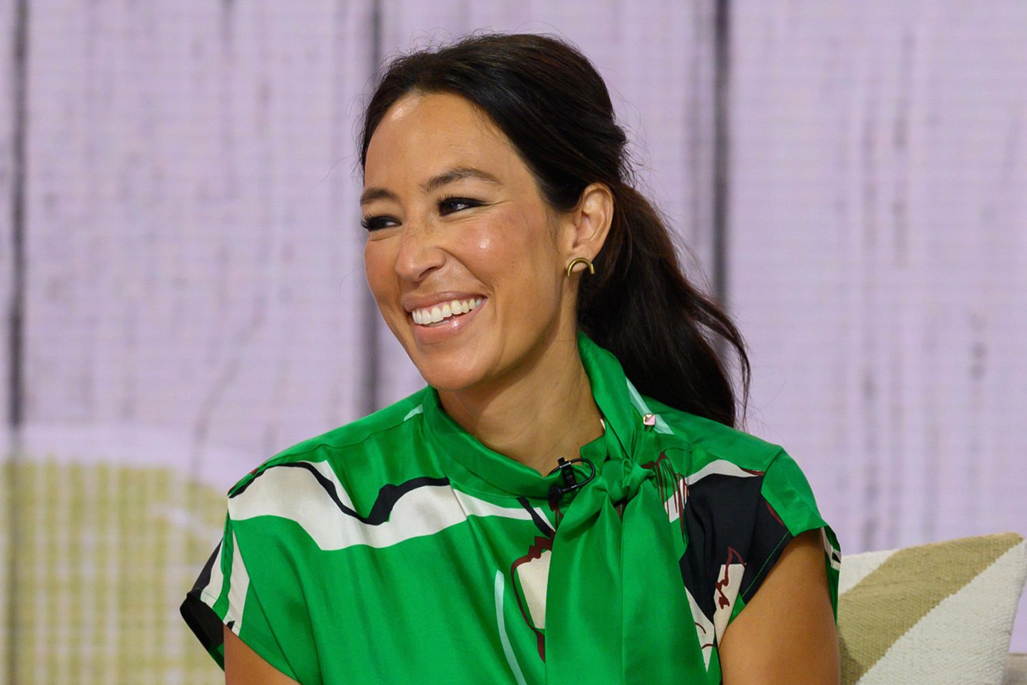 Joanna Gaines laughing and wearing a green top