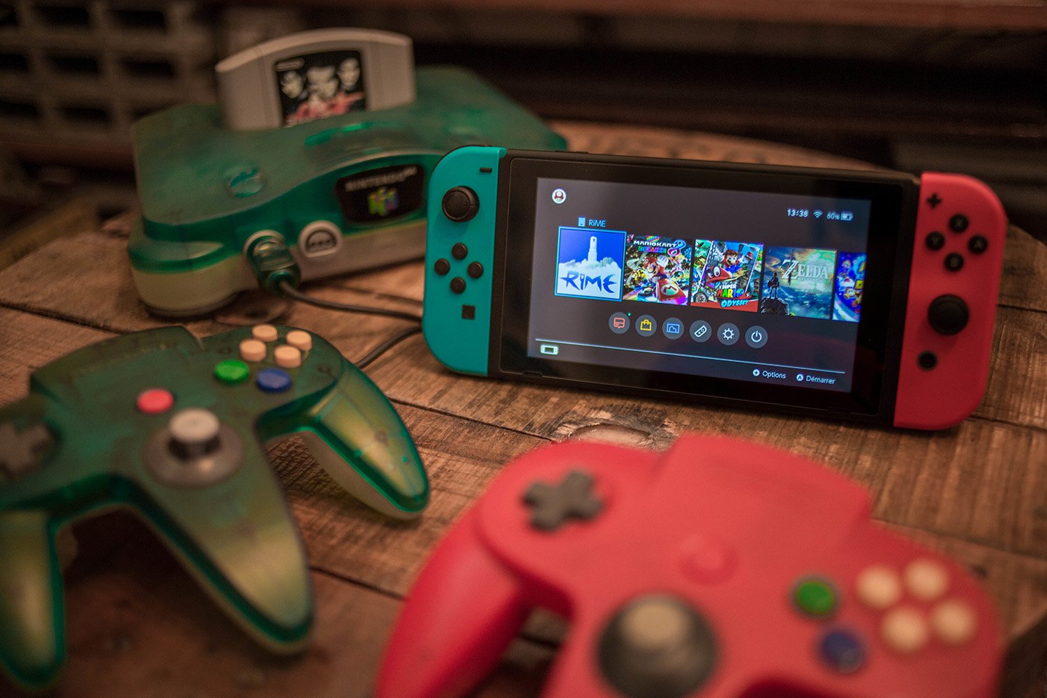 A blue Nintendo 64 console and its controllers beside a Nintendo Switch console and its Joy-Cons
