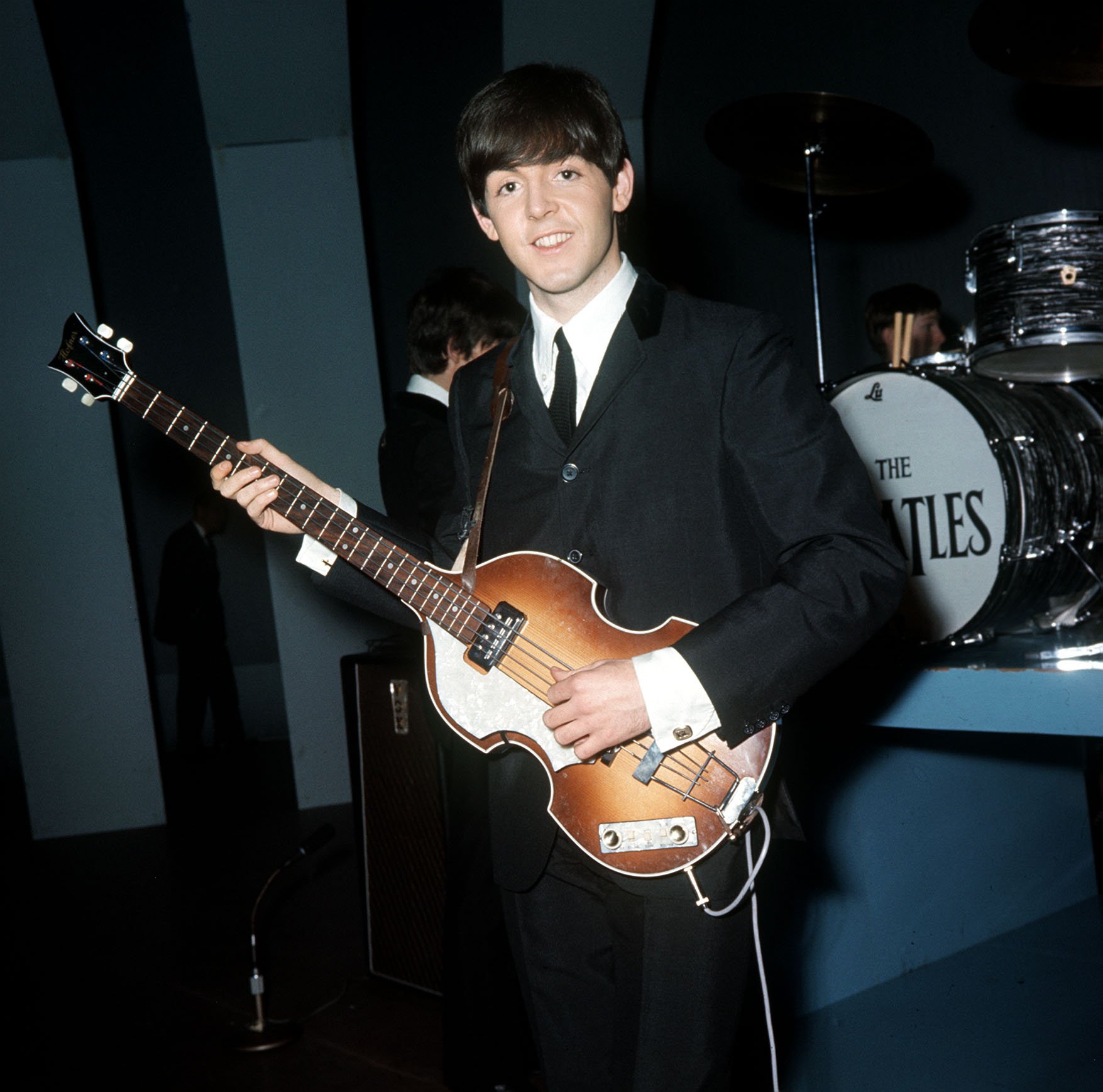 The Beatles' Paul McCartney playing songs on a guitar
