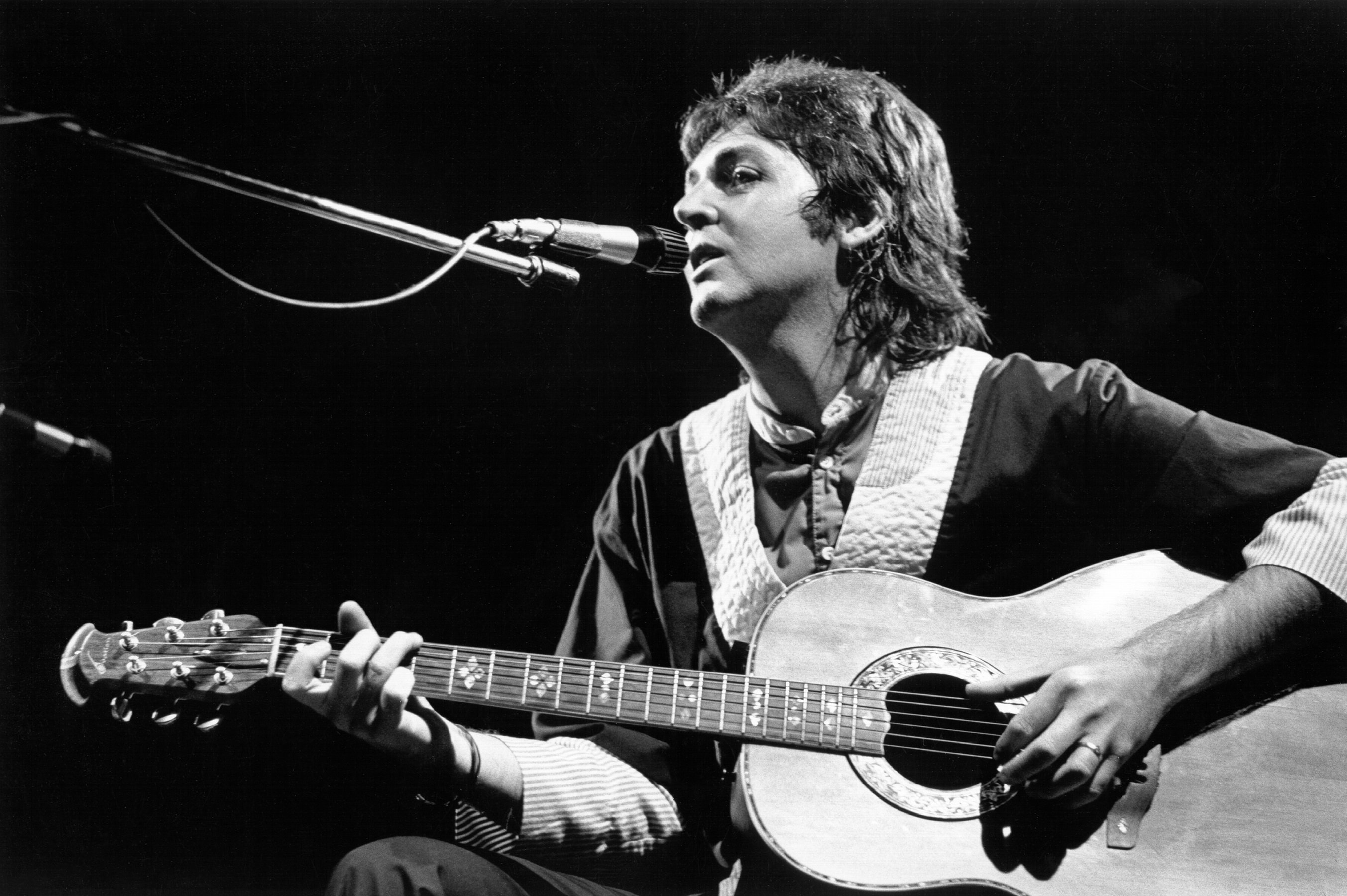 Paul McCartney playing songs on a guitar